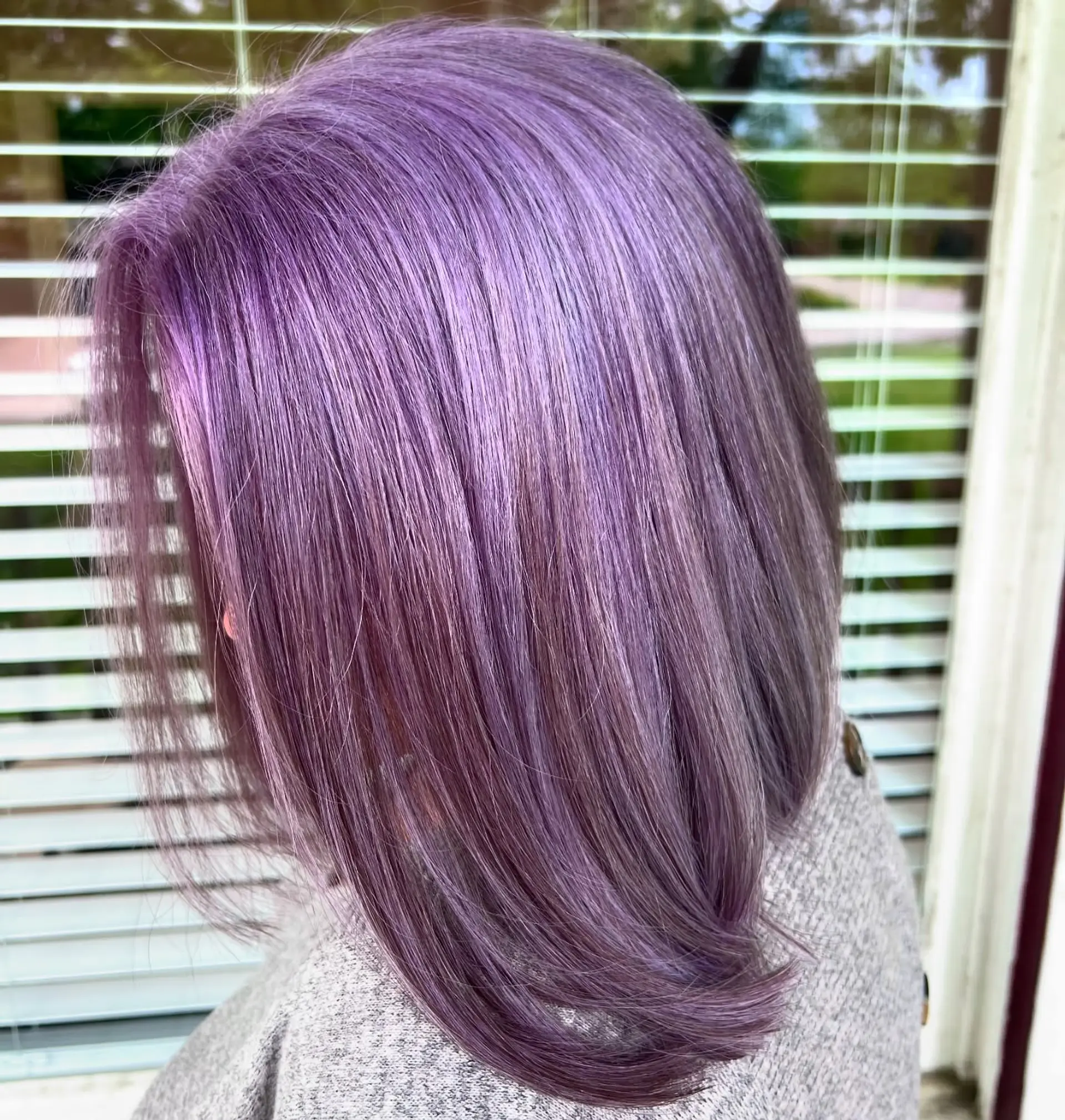 A sleek, short bob with a blunt cut, vibrantly colored in a vivid lavender and violet hue. 1