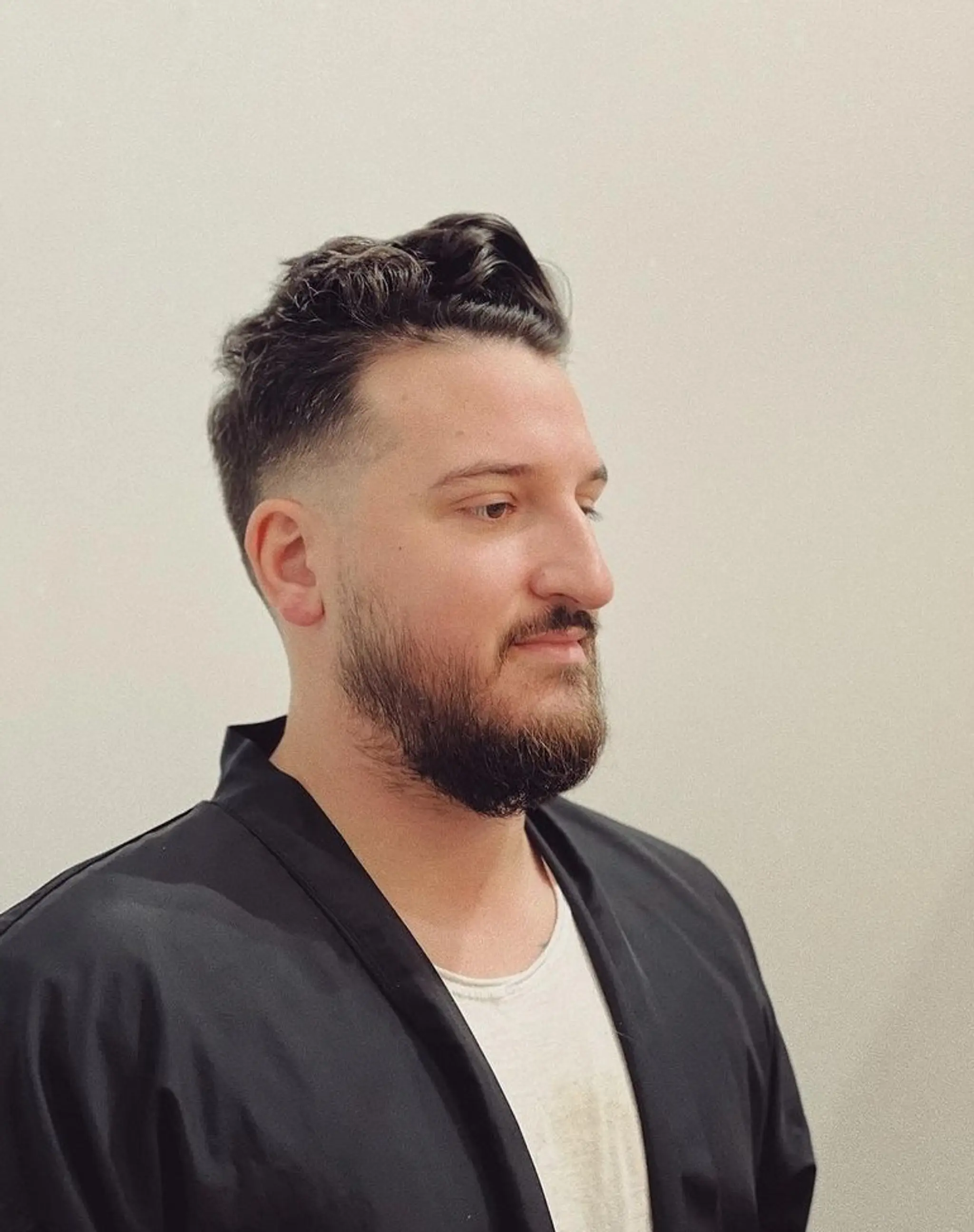 A sleek Modern Pompadour Fade with a high fade on the sides and back, paired with a full, well-groomed beard, showcasing a polished and contemporary appearance.

by @sdrhair
