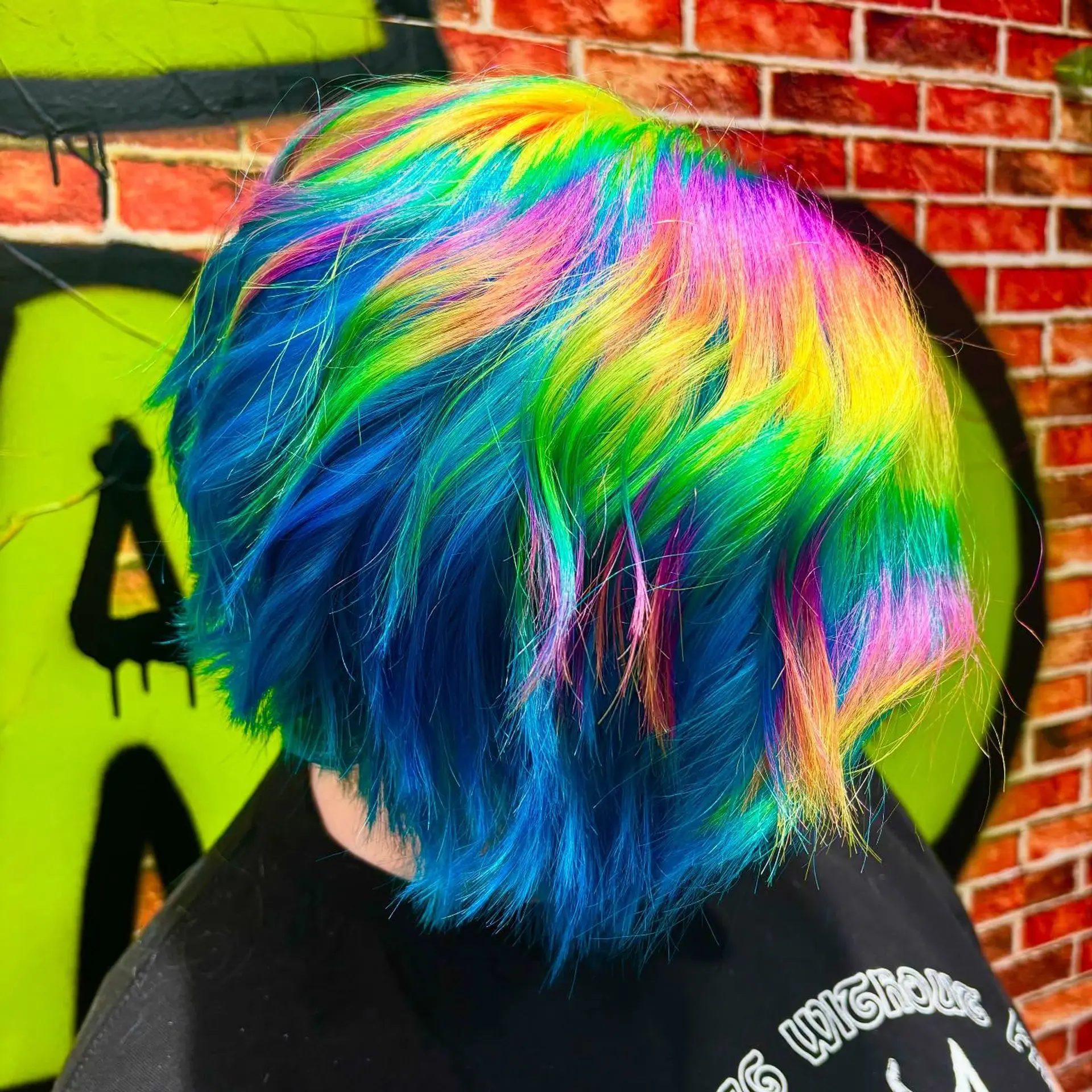 A textured short bob colored with bright multi-tonal holographic rainbow shades over a vivid blue base. 1
