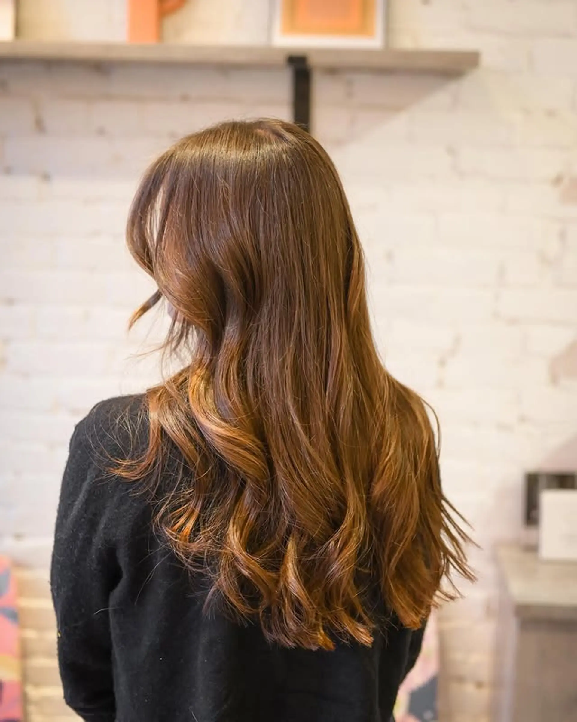 Long, layered, wavy hairstyle with bronzed copper tones and face-framing layers. 1