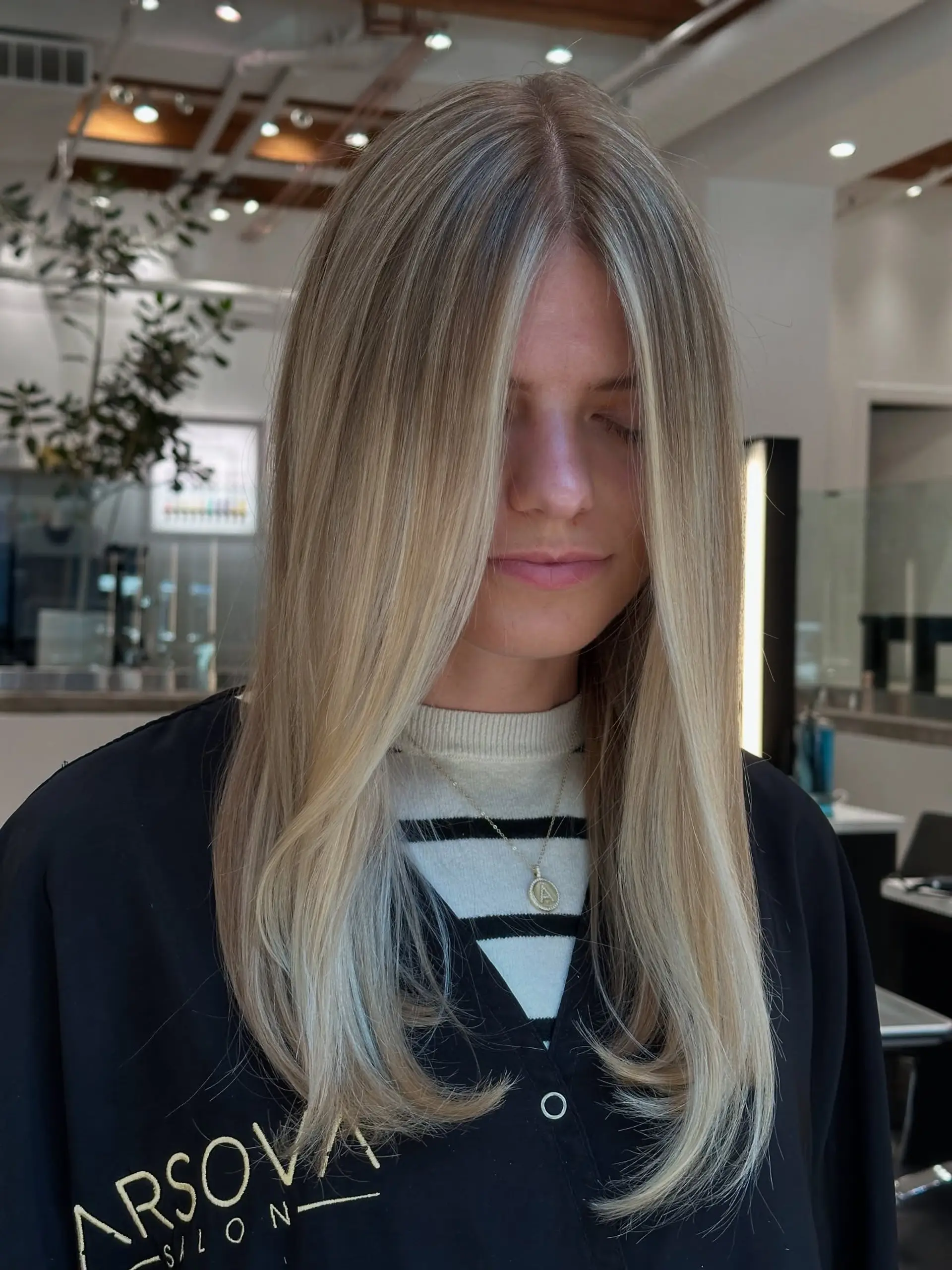 Long straight hair with face-framing layers and a blonde money piece. 1