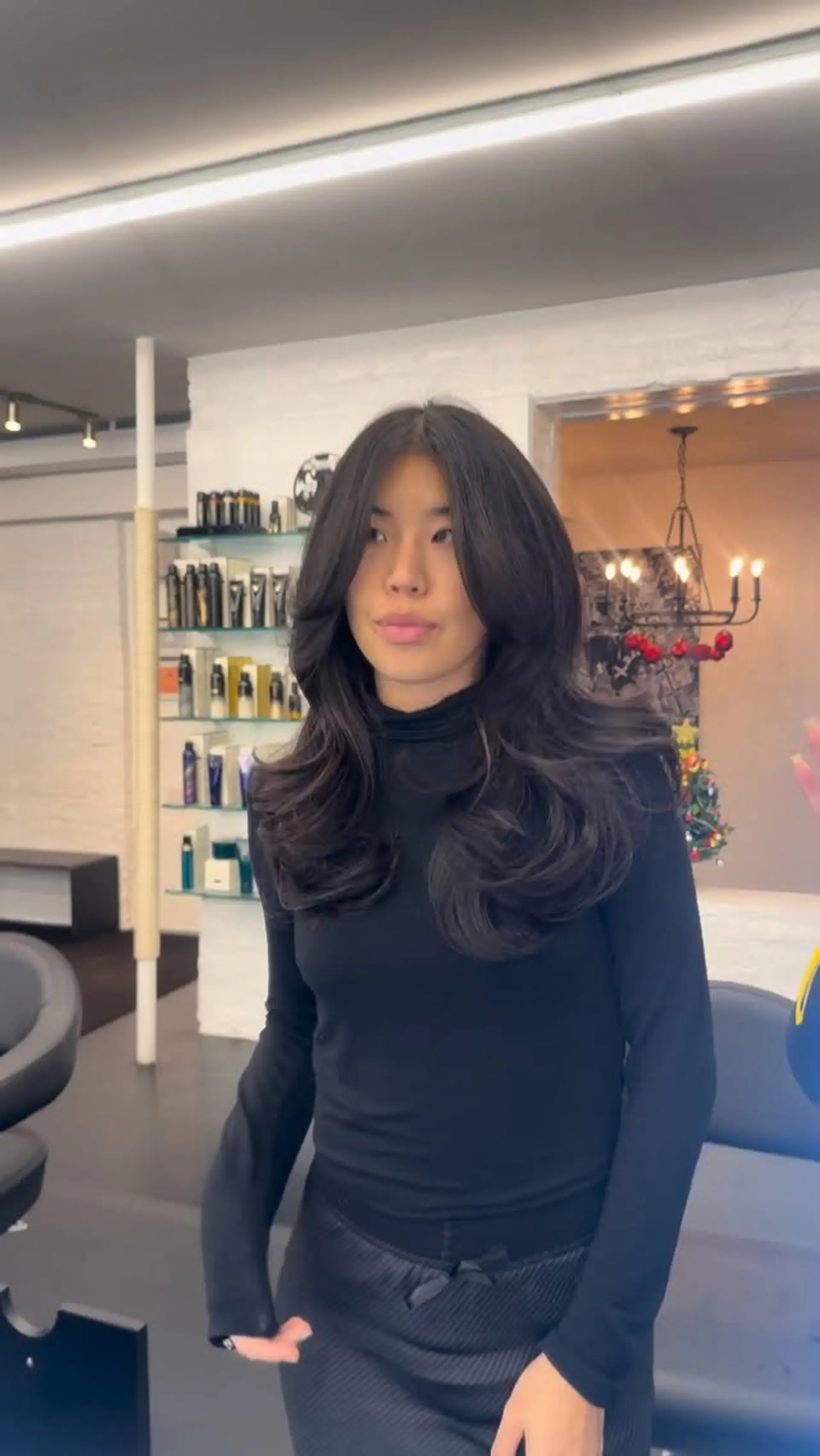 A glamorous, high-volume blowout on long dark hair featuring feathered face-framing layers and rounded, curled ends. 1