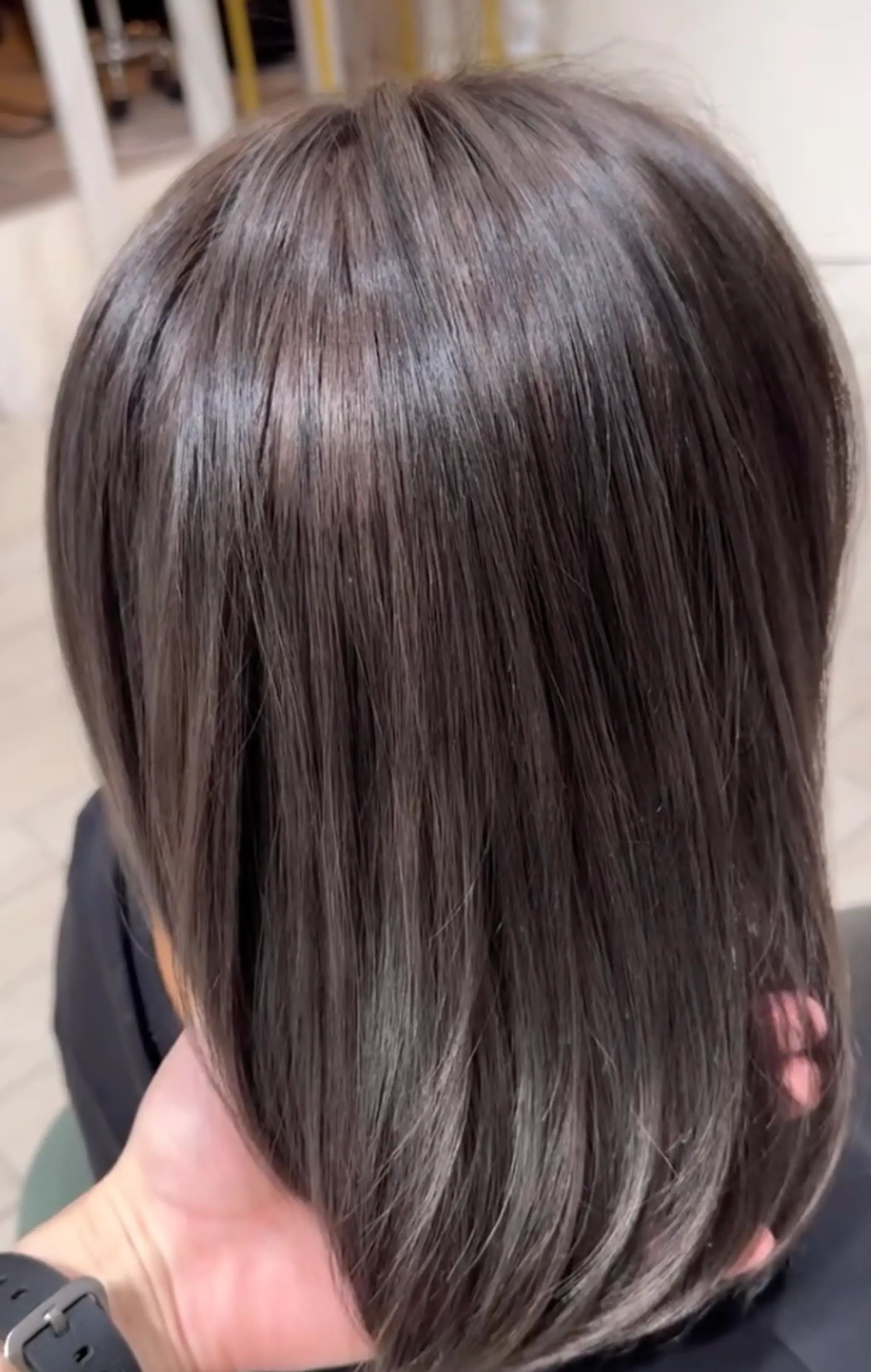 Medium-length, straight, and sleek black hair with a glossy shine, perfectly smooth and straightened.