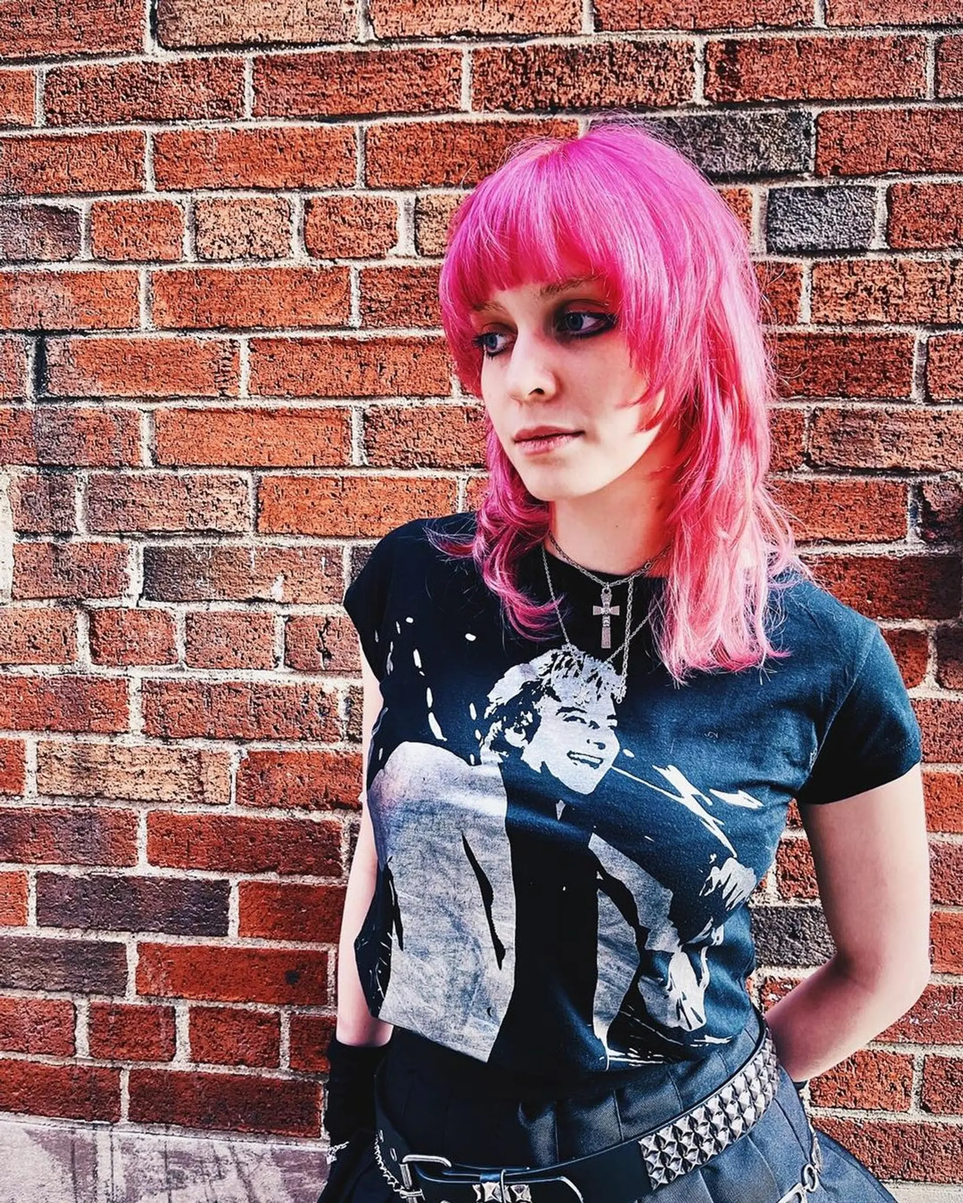 A vibrant pink medium-length mullet featuring layers, wavy texture, and a soft fringe of bangs covering the forehead, creating a look full of movement and definition by Lynn. 2