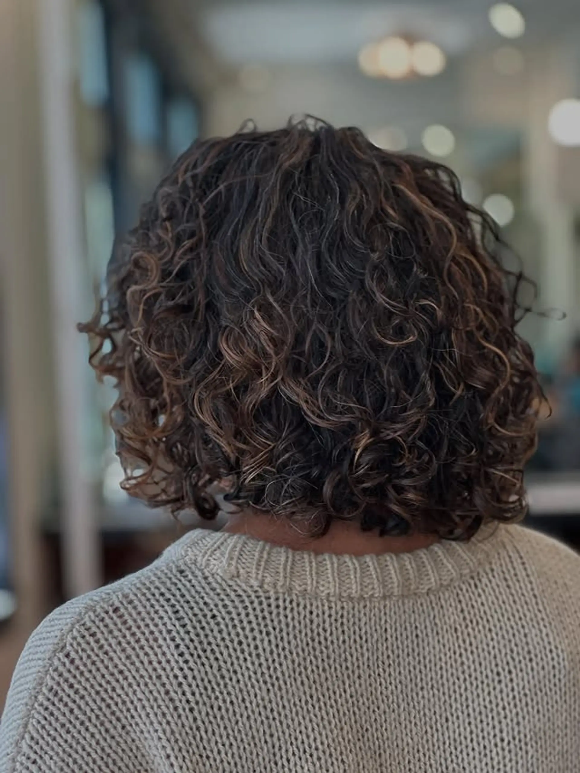 A curly bob that enhances natural texture and adds dimension with subtle highlights. 1