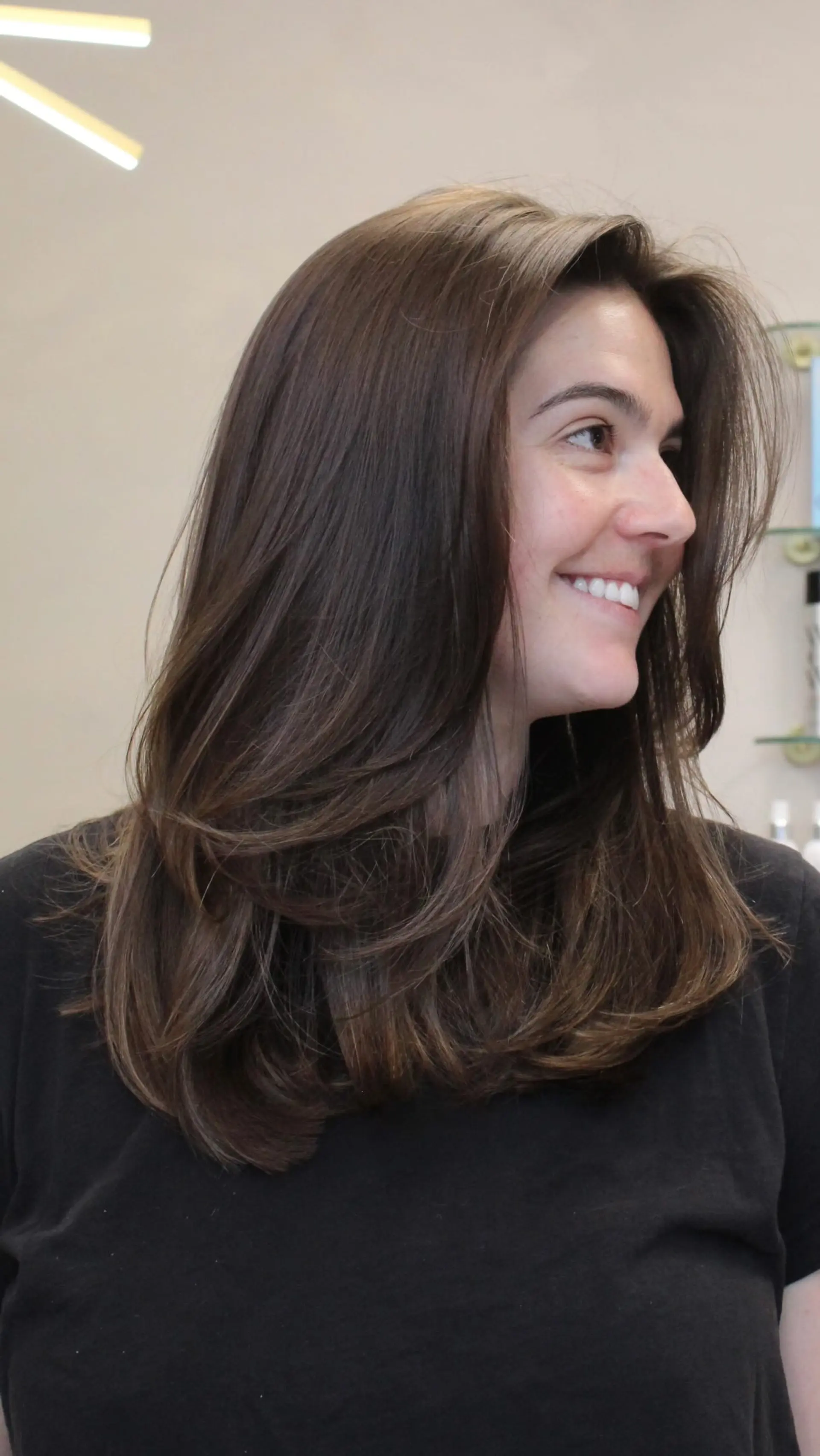 A long, smooth brunette hairstyle cut with soft face-framing layers and rounded, curled-under ends. 1