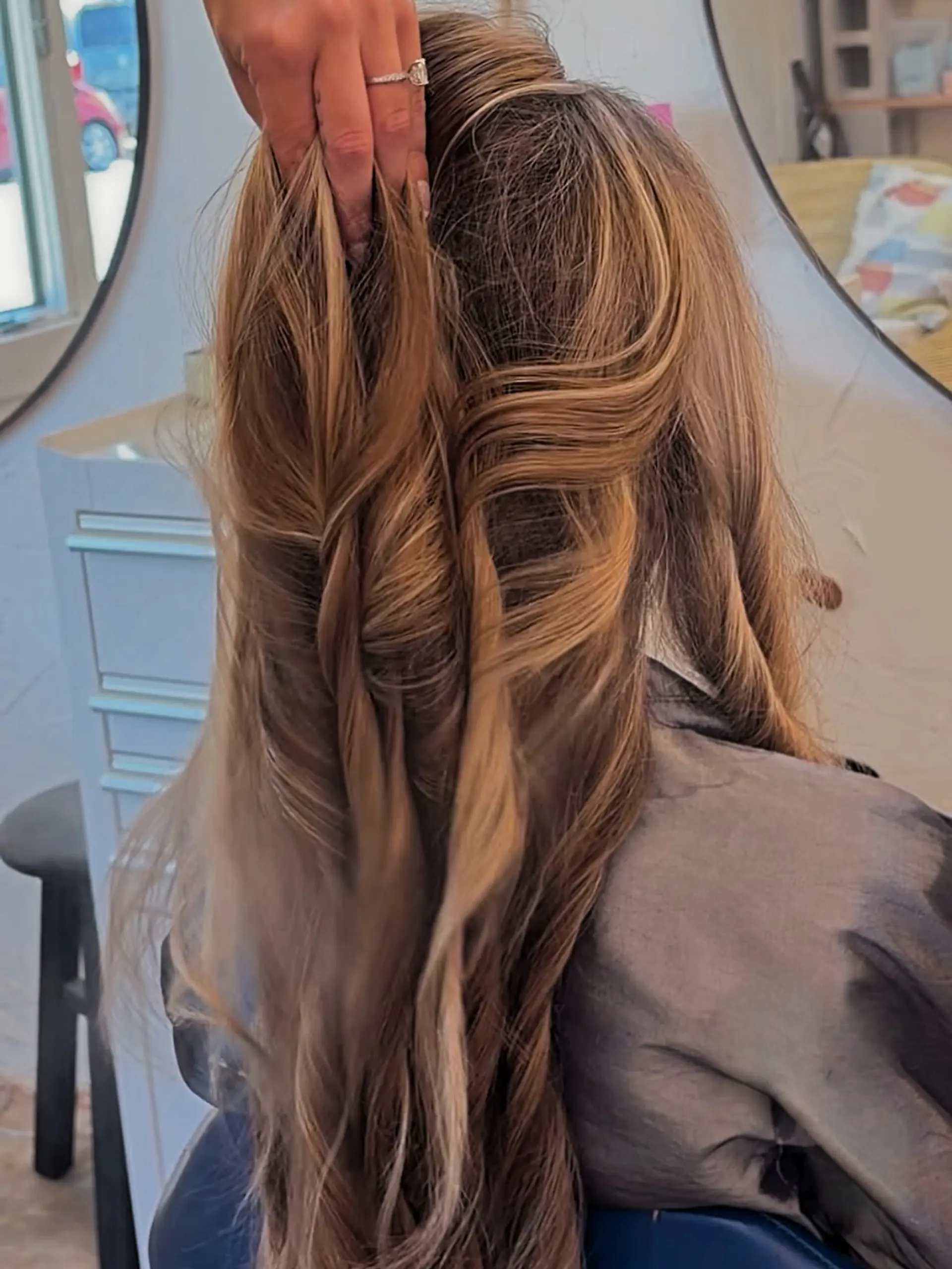Long warm blonde hair styled in loose salon curls, showing off dimension from full highlighting techniques. 1