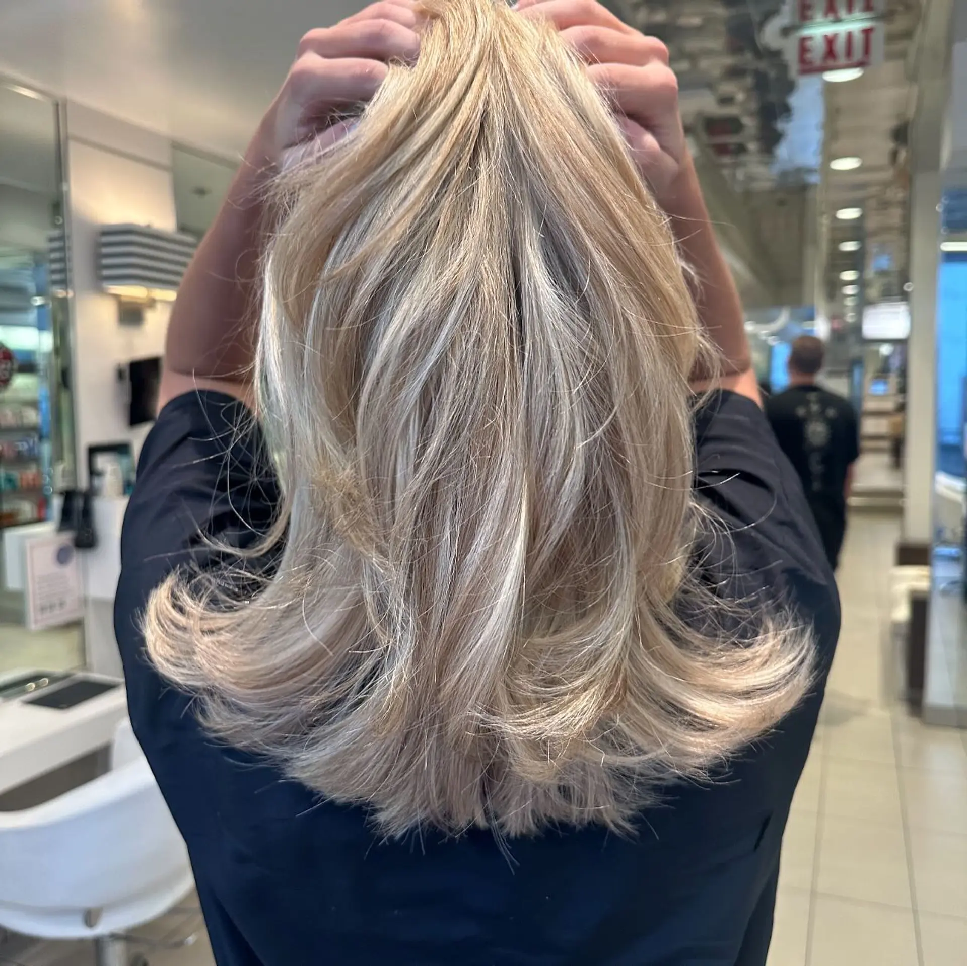 Medium-length blonde hair styled with feathered layers and outward flipped ends. 1