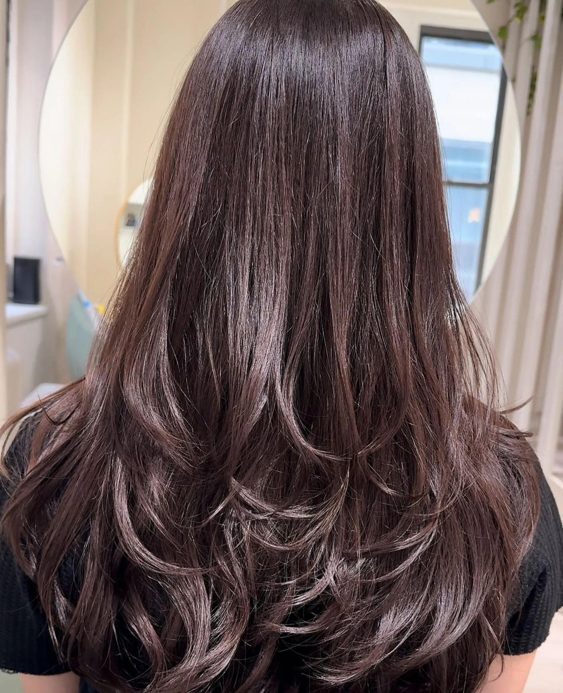Long, wavy hair with a rich brown color, cut into flowing layers that cascade down the back with a shiny finish and soft texture. 1