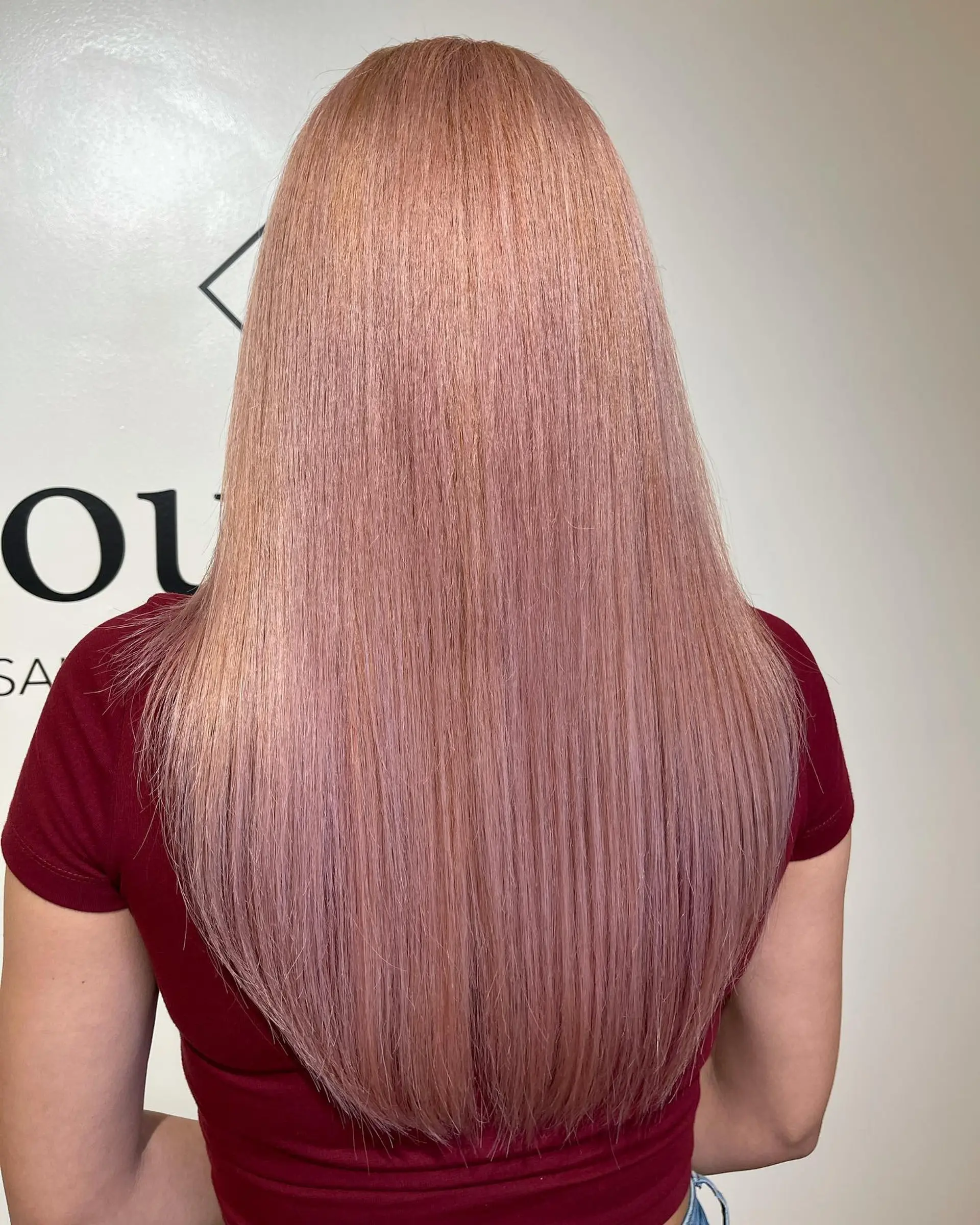 Long, sleek straight hair colored in a soft pastel pink tone with a gentle taper towards the ends. 1
