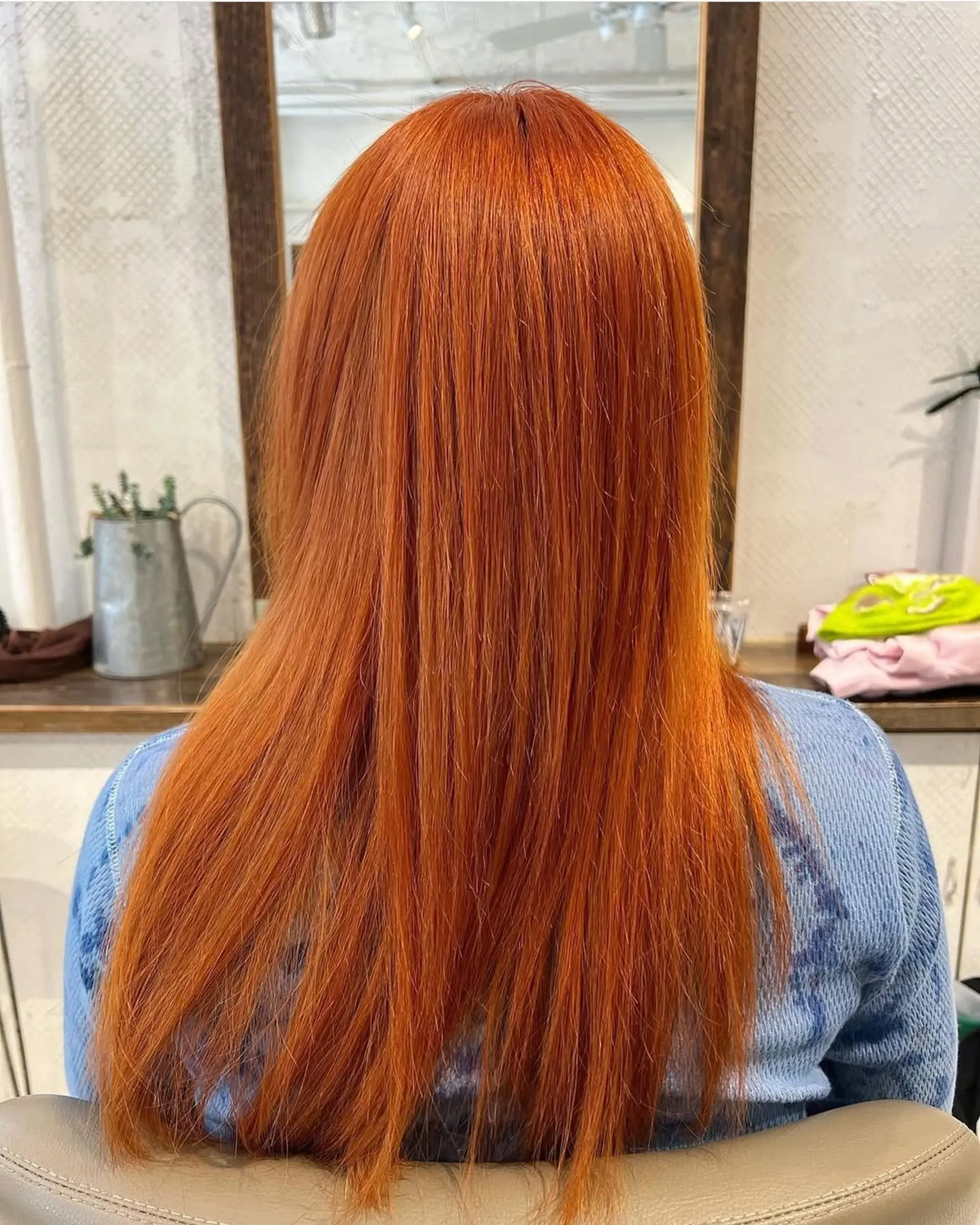 The hair features a vibrant copper shade, styled straight and long with a sleek finish. 1
