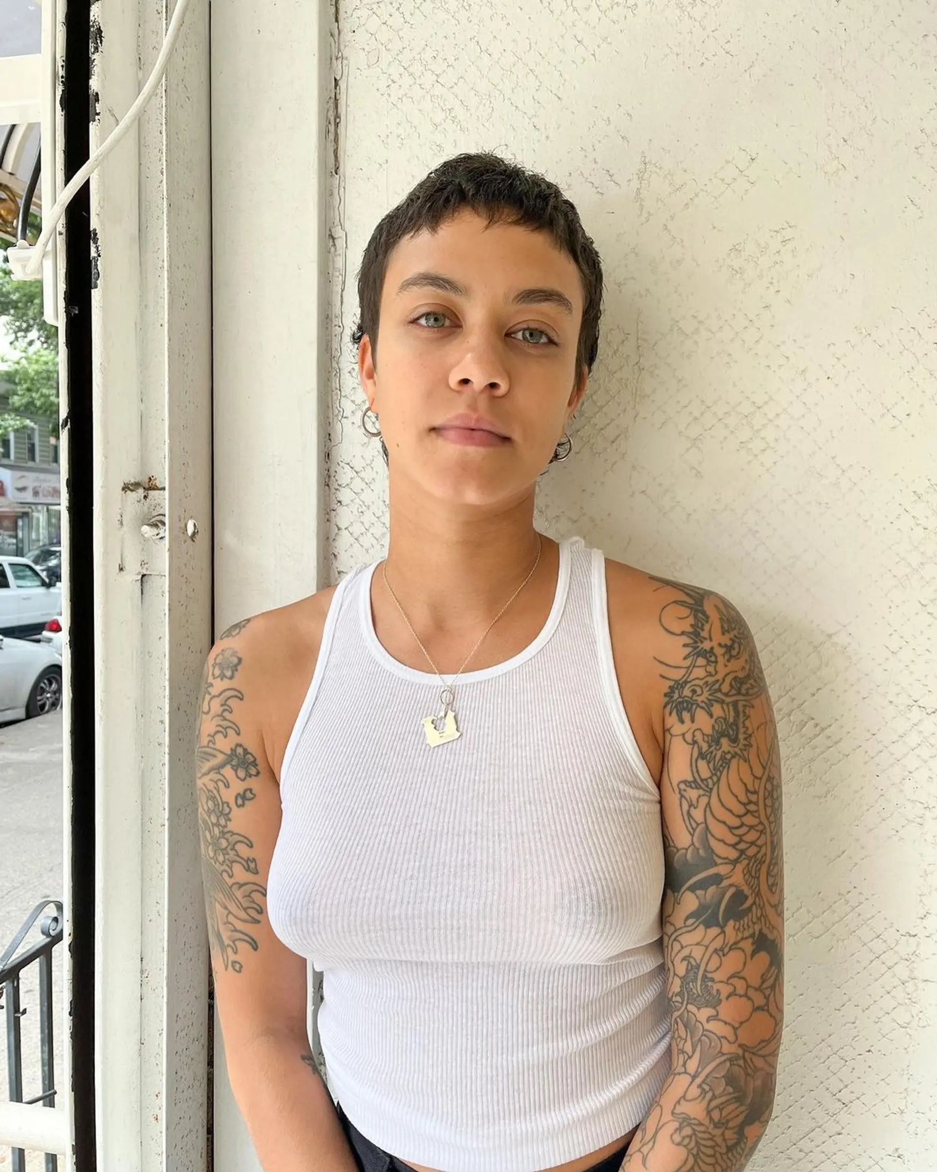 Short, naturally wavy hair styled into an edgy pixie cut with textured waves and a subtle fringe. 3