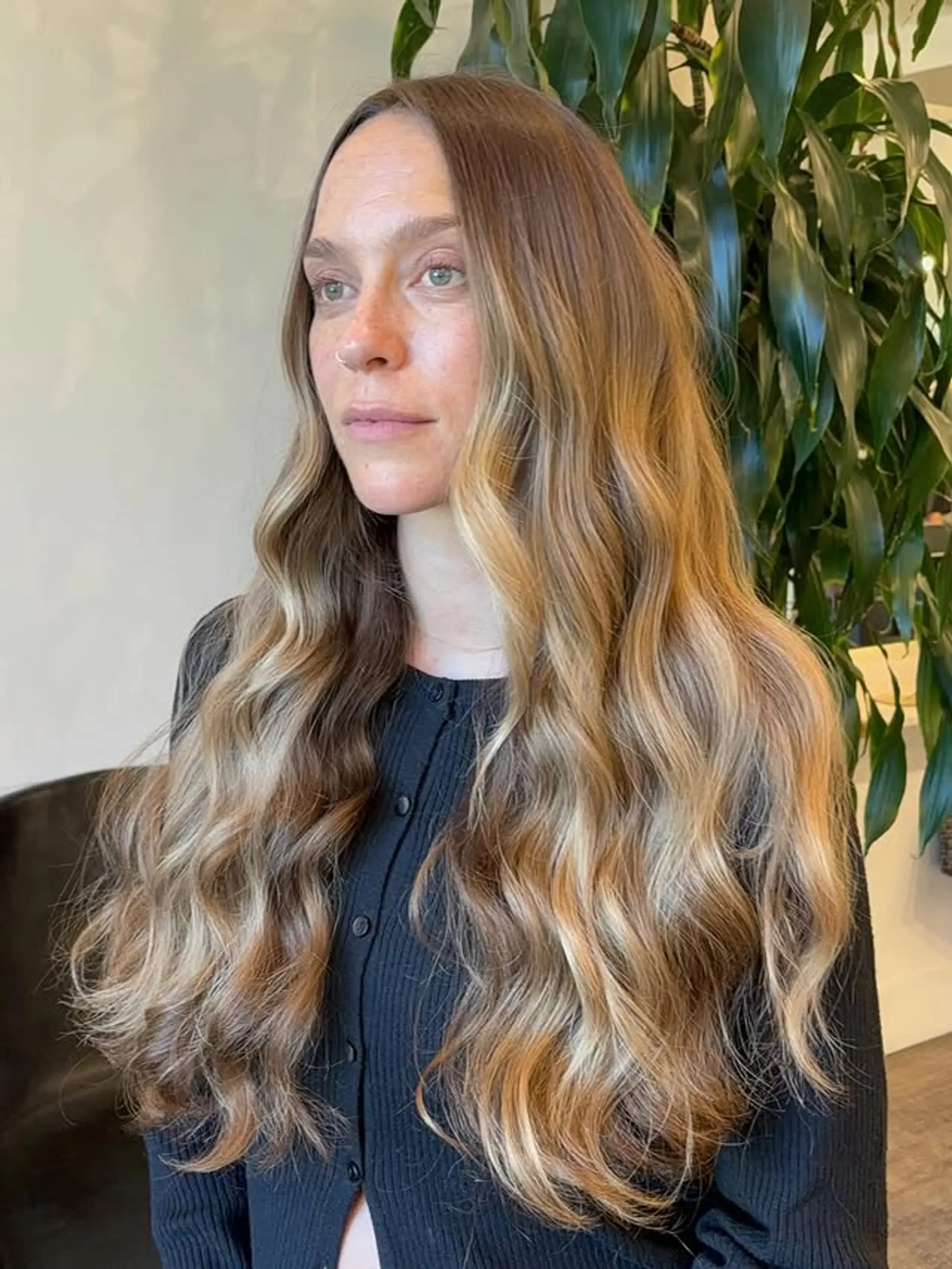 Long wavy hair with a bronde balayage, featuring a seamless blend of brown and blonde tones for a sun-kissed effect. 1