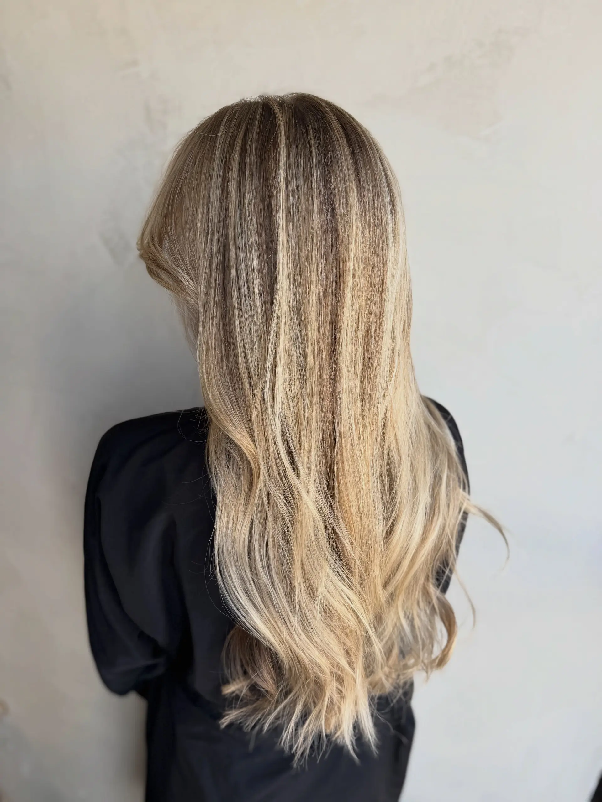 Long hair featuring finely blended multi-tonal blonde highlights over a neutral base, styled smooth with subtle movement at the ends. 1