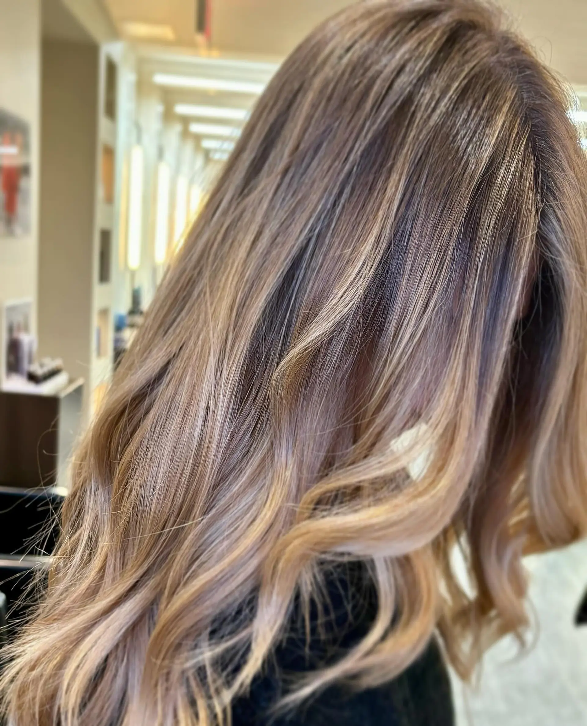 Seamlessly blended bronde balayage on long hair styled with loose curls at the ends. 1