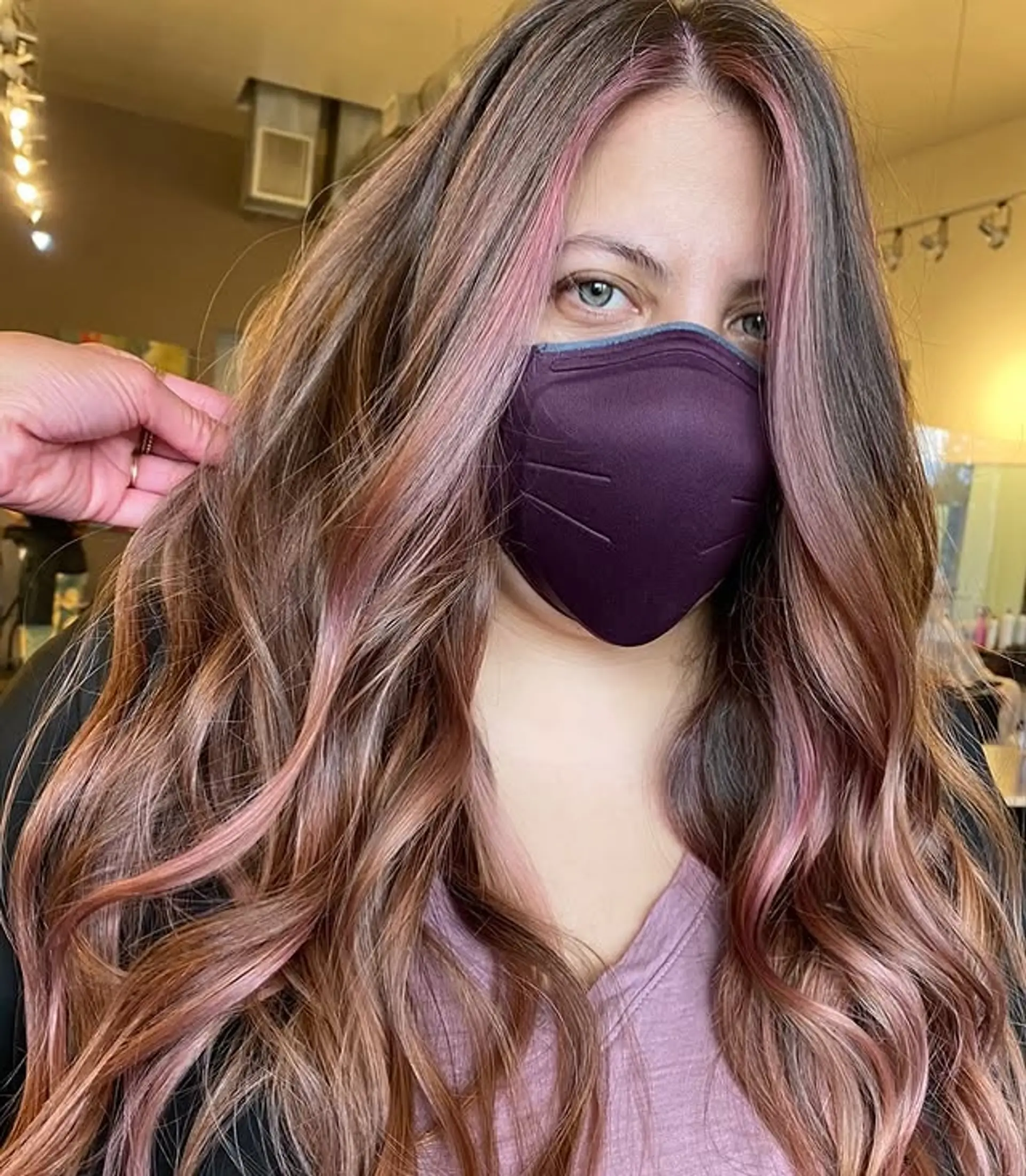 A stylish balayage with rose gold and subtle pink highlights, styled into soft, flowing waves. 1