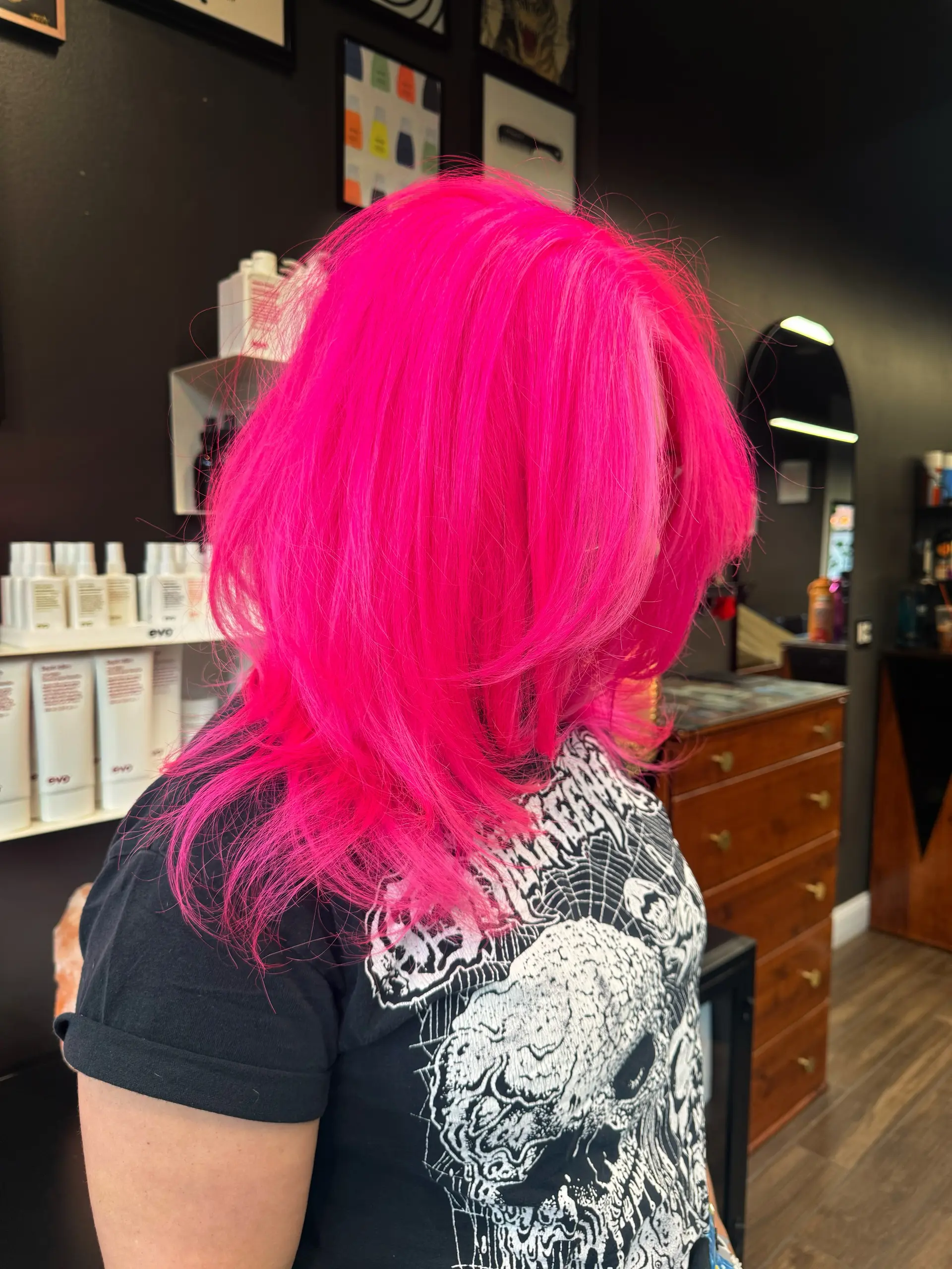 A bold mid-length haircut featuring an ultra-bright neon pink color with textured, layered ends. 1