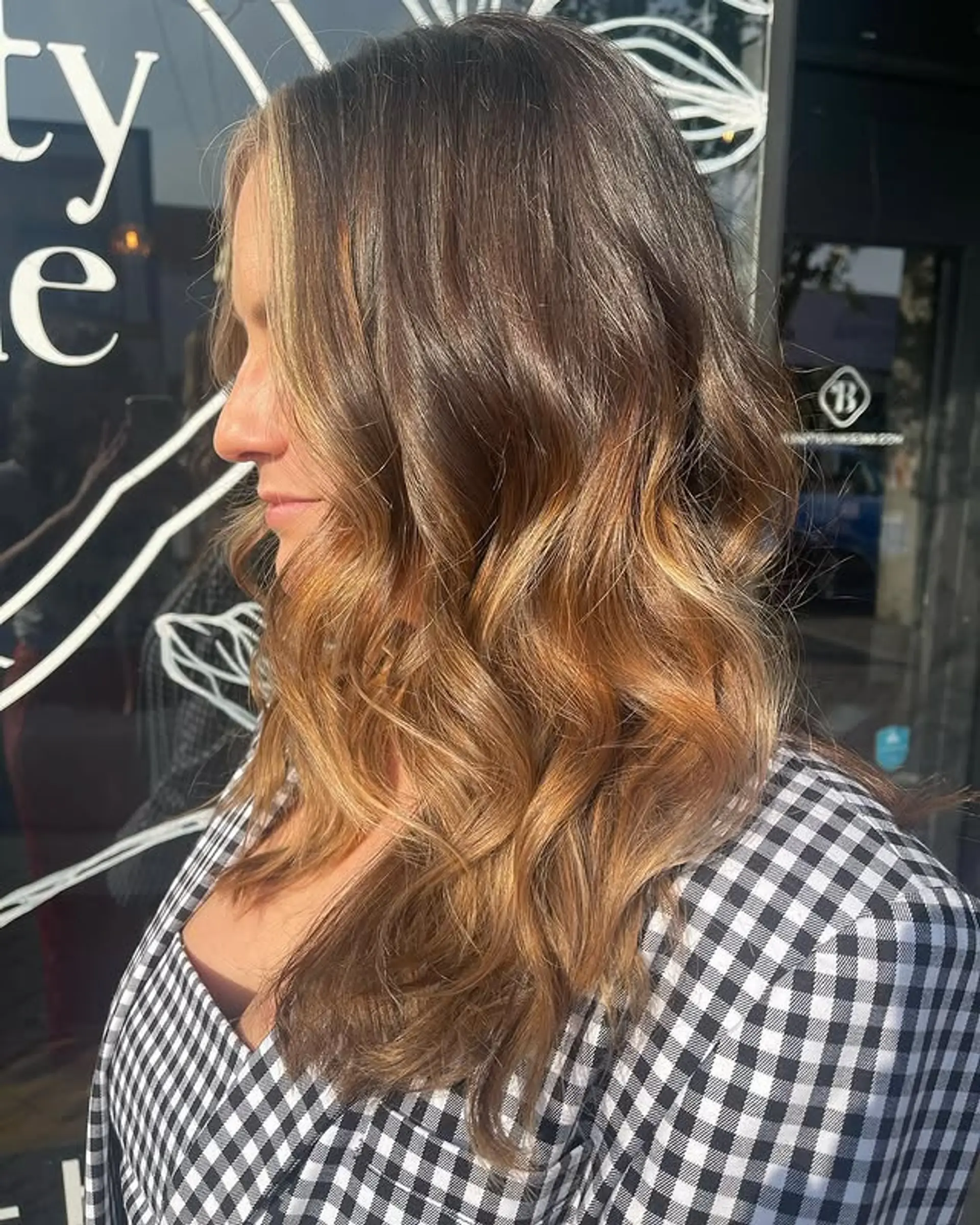 A trendy bronde balayage with soft, subtle waves and a dimensional color. 1