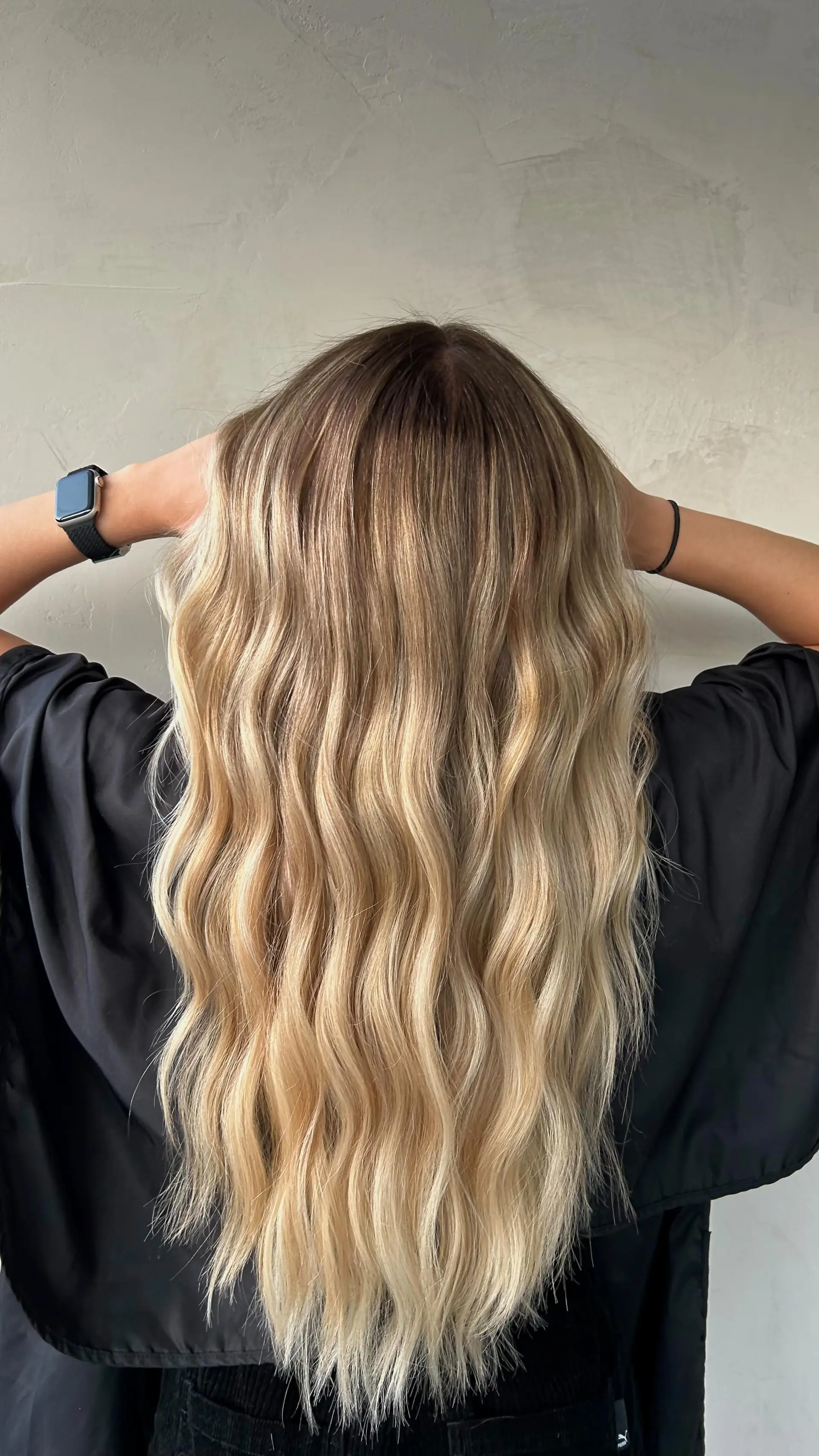Long hair styled with soft, undone waves featuring a bright multi-dimensional blonde blend and a natural shadowed root. 1