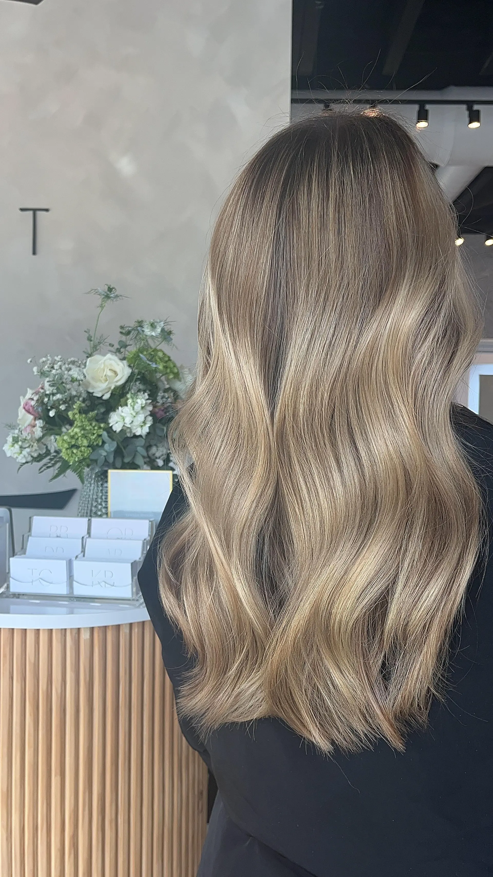 Long hair featuring a seamless blend of dimensional blonde tones styled into soft, effortless waves. 1