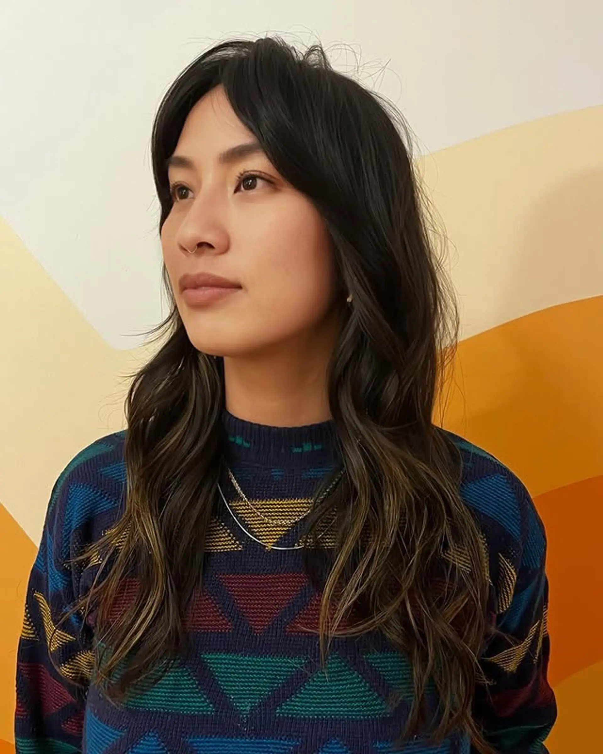 Long, wavy hair with layered face-framing highlights for a modern and low-maintenance look. 1