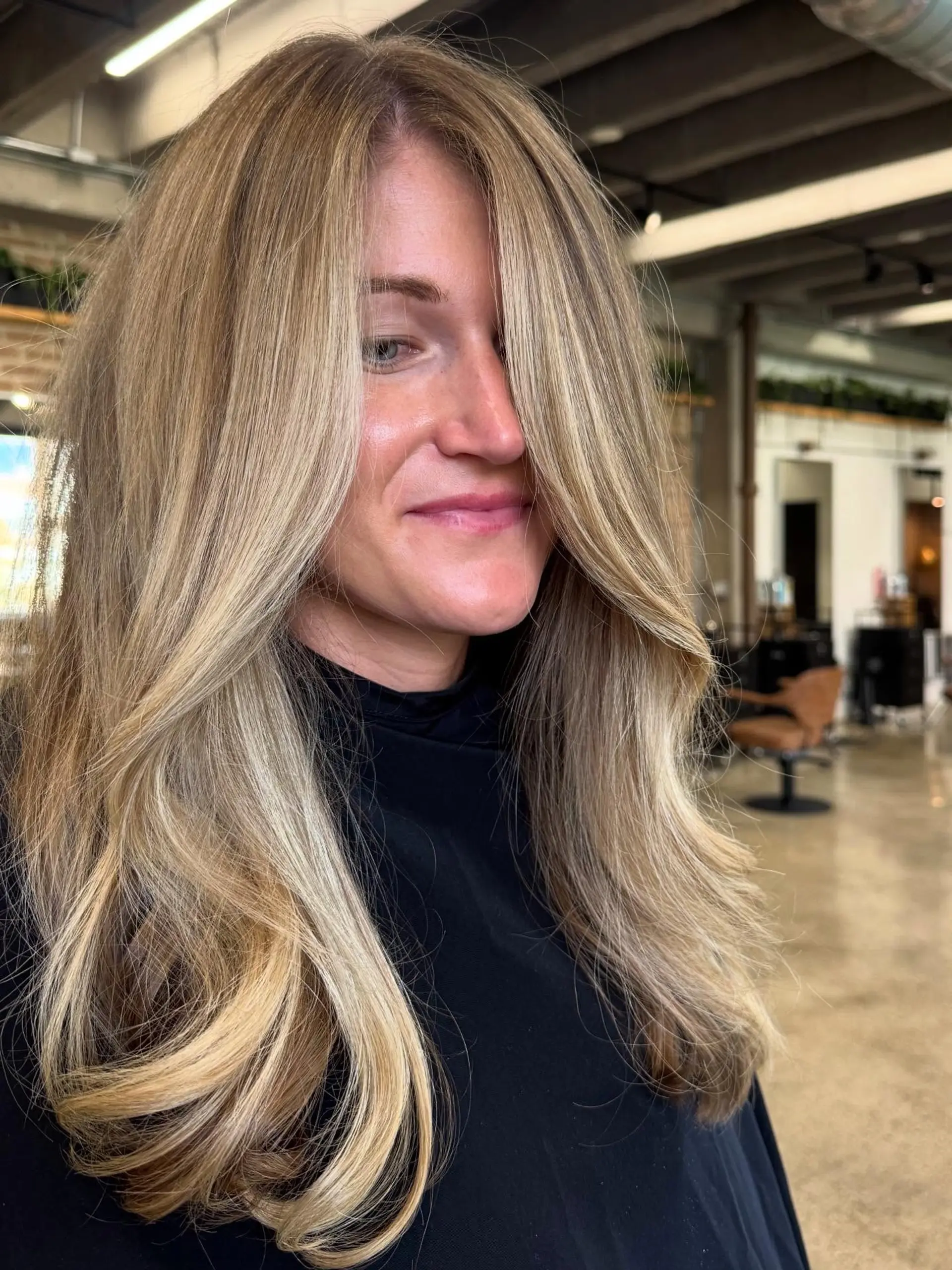 This long, wavy hairstyle showcases soft, flowing layers with a face-framing cut that adds volume and movement. The hair is styled with loose, bouncy curls, highlighting the natural-looking balayage effect. 2