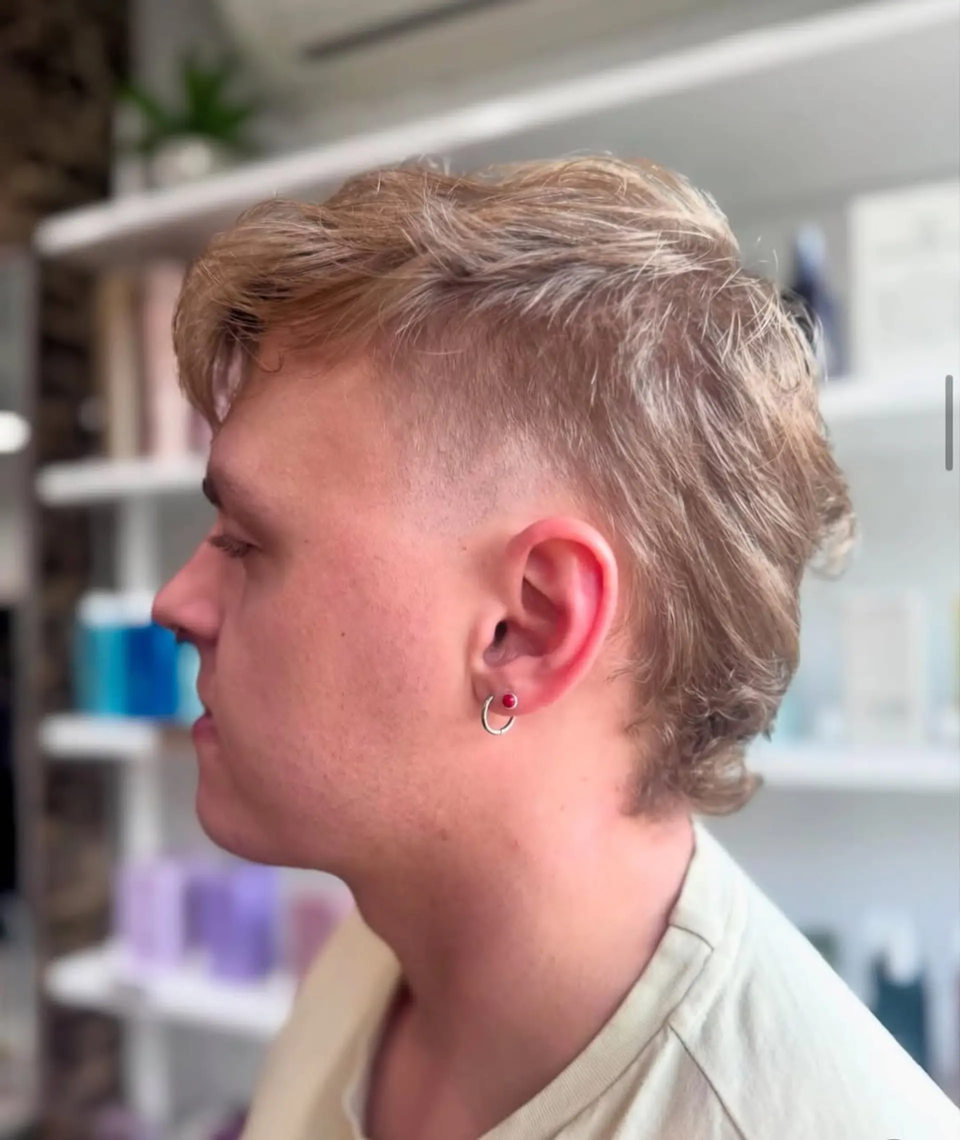 A modern mullet fade, characterized by very short faded sides, a textured wavy top, and a longer, shaggy back for a trendy and edgy appeal. 1
