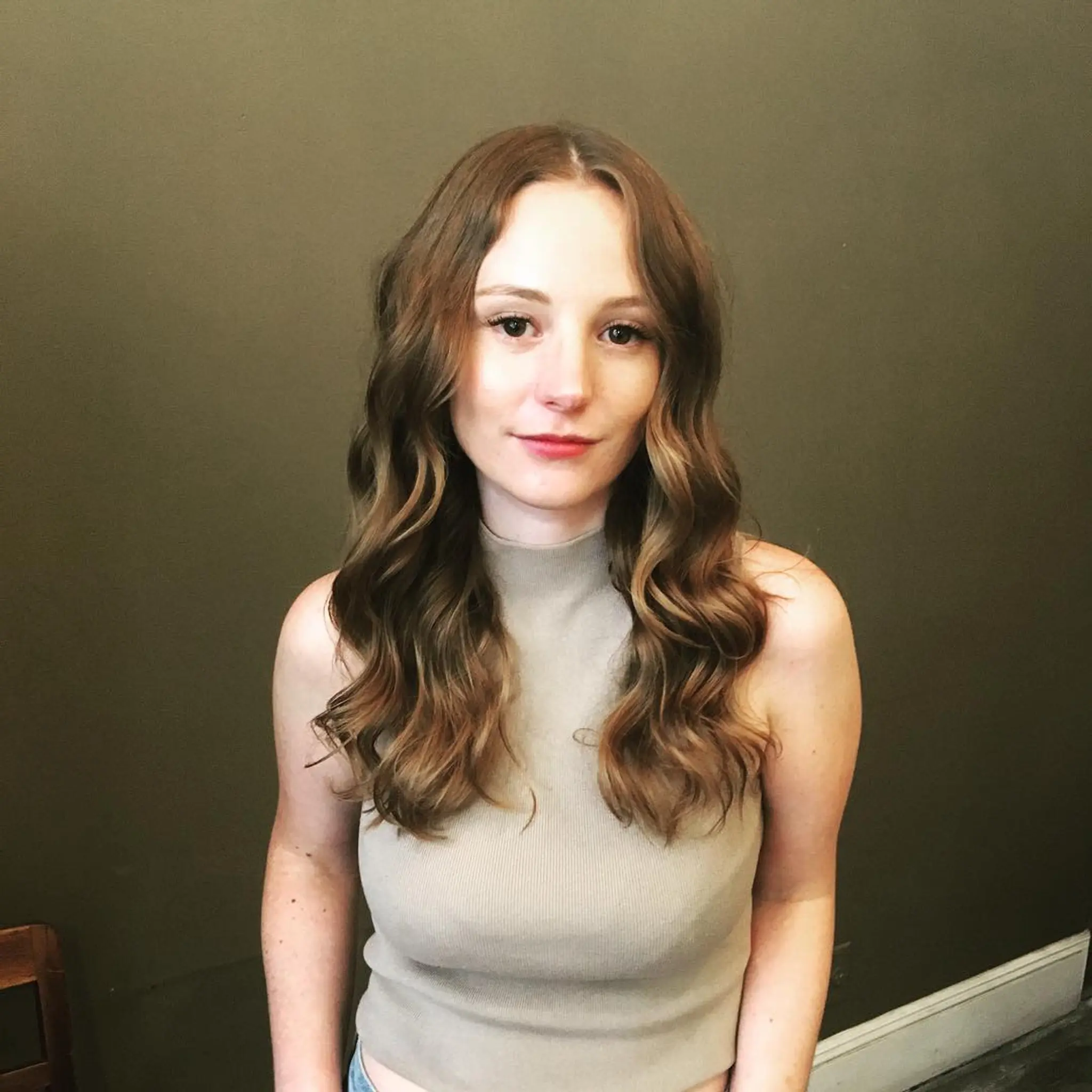 Soft, cascading waves with a center part and a natural shine, flowing past the shoulders in a light brown hue.