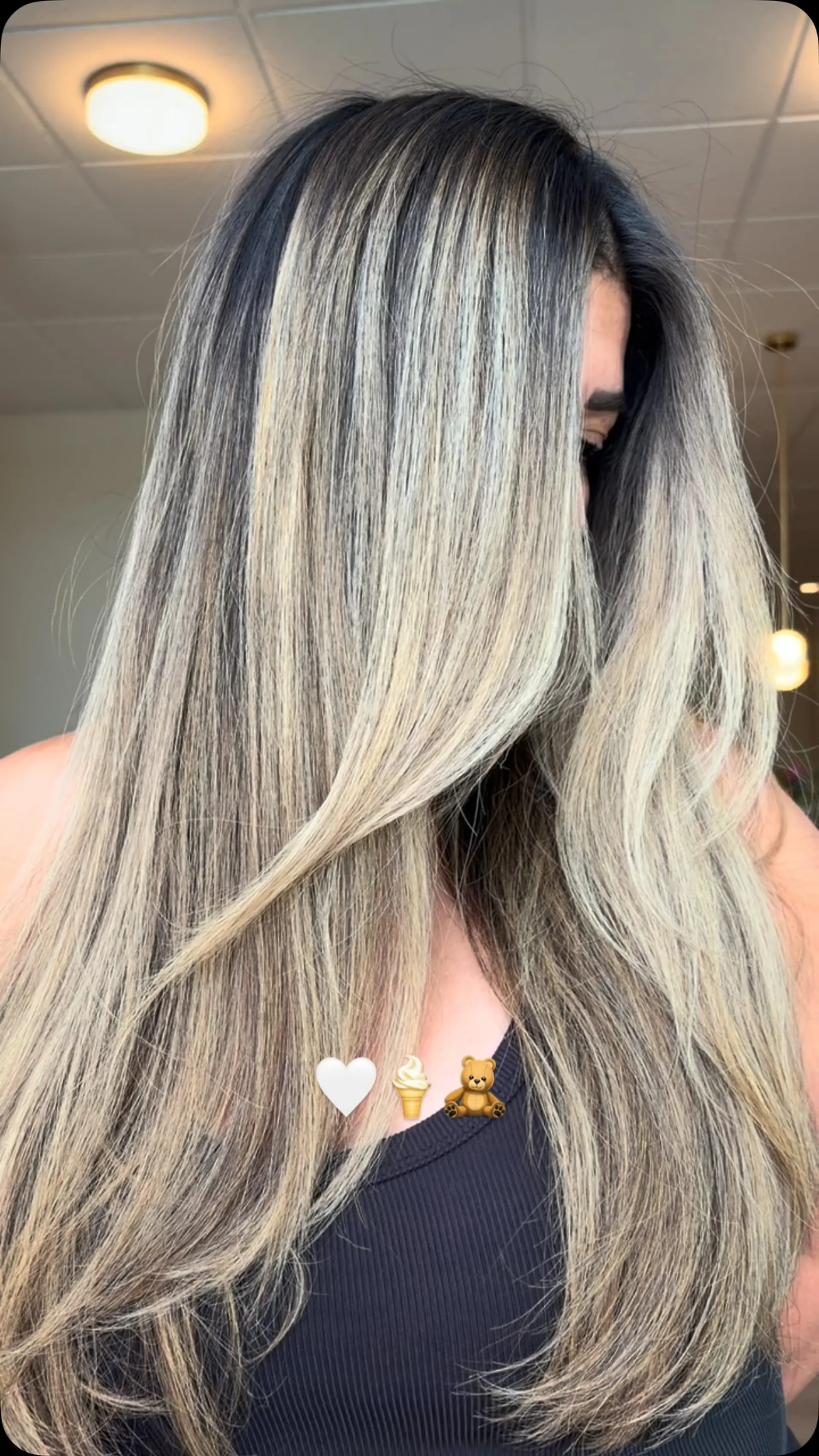 Long, smoothly styled hair featuring seamless ash blonde highlights blended into a dark brunette base. 1