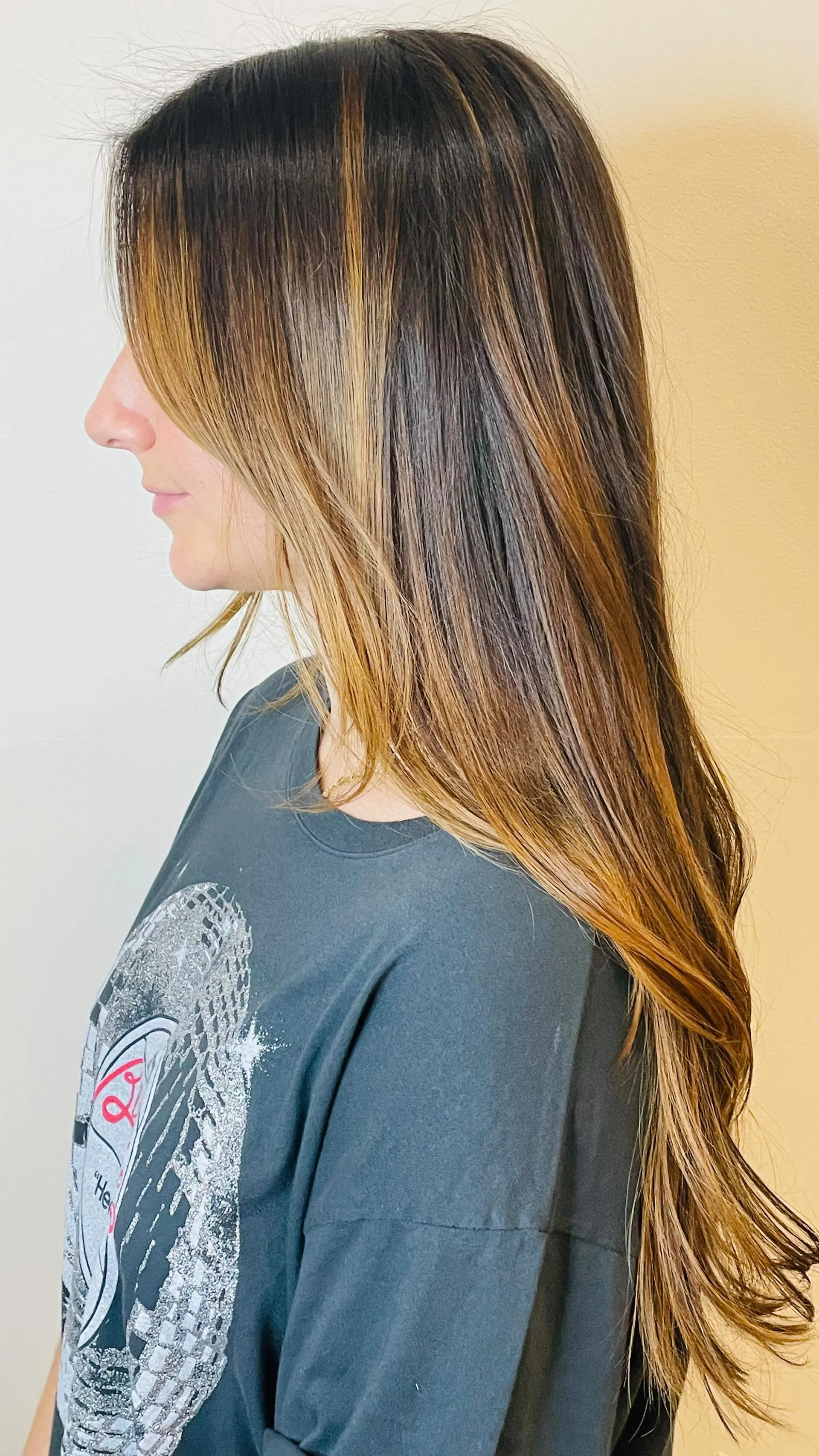 Extra-long layered brunette hair with warm caramel balayage highlights and soft face-framing strands. 1