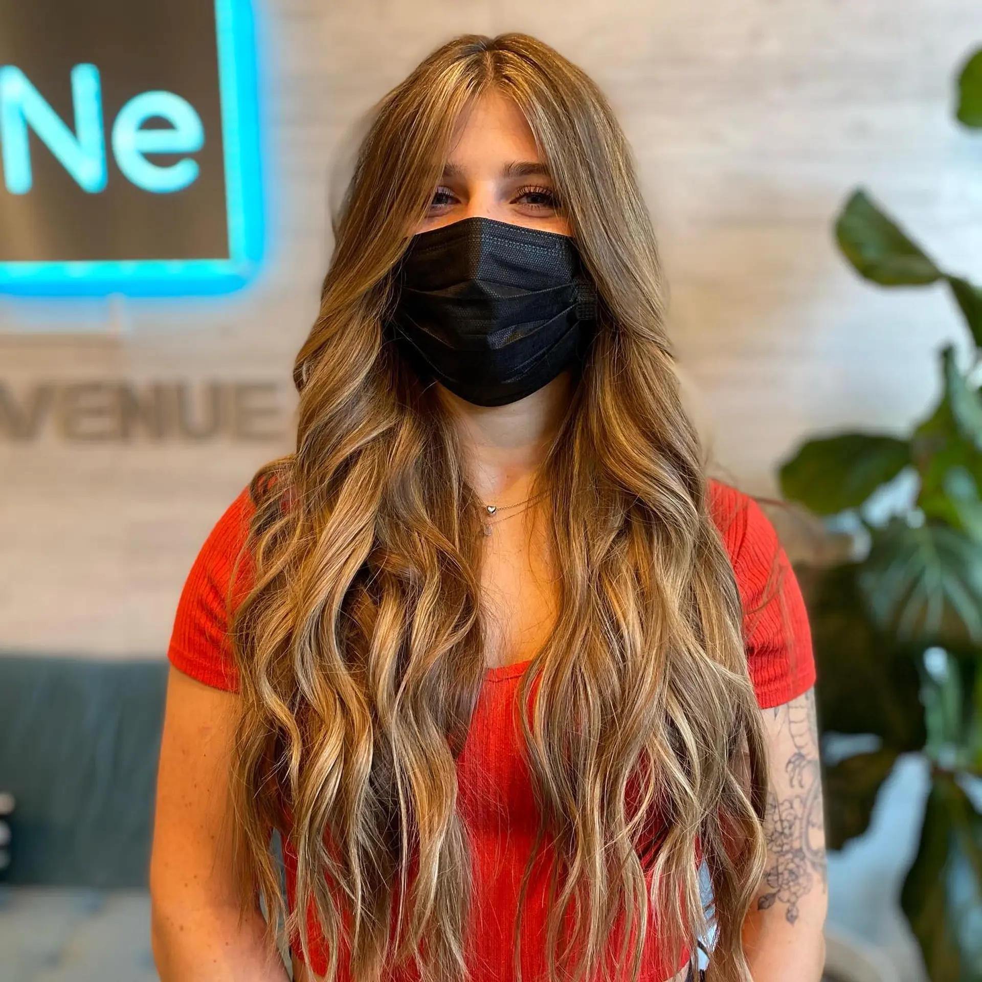 Extra-long hair styled in loose, textured waves featuring dimensional warm blonde highlights and face-framing curtain bangs. 1
