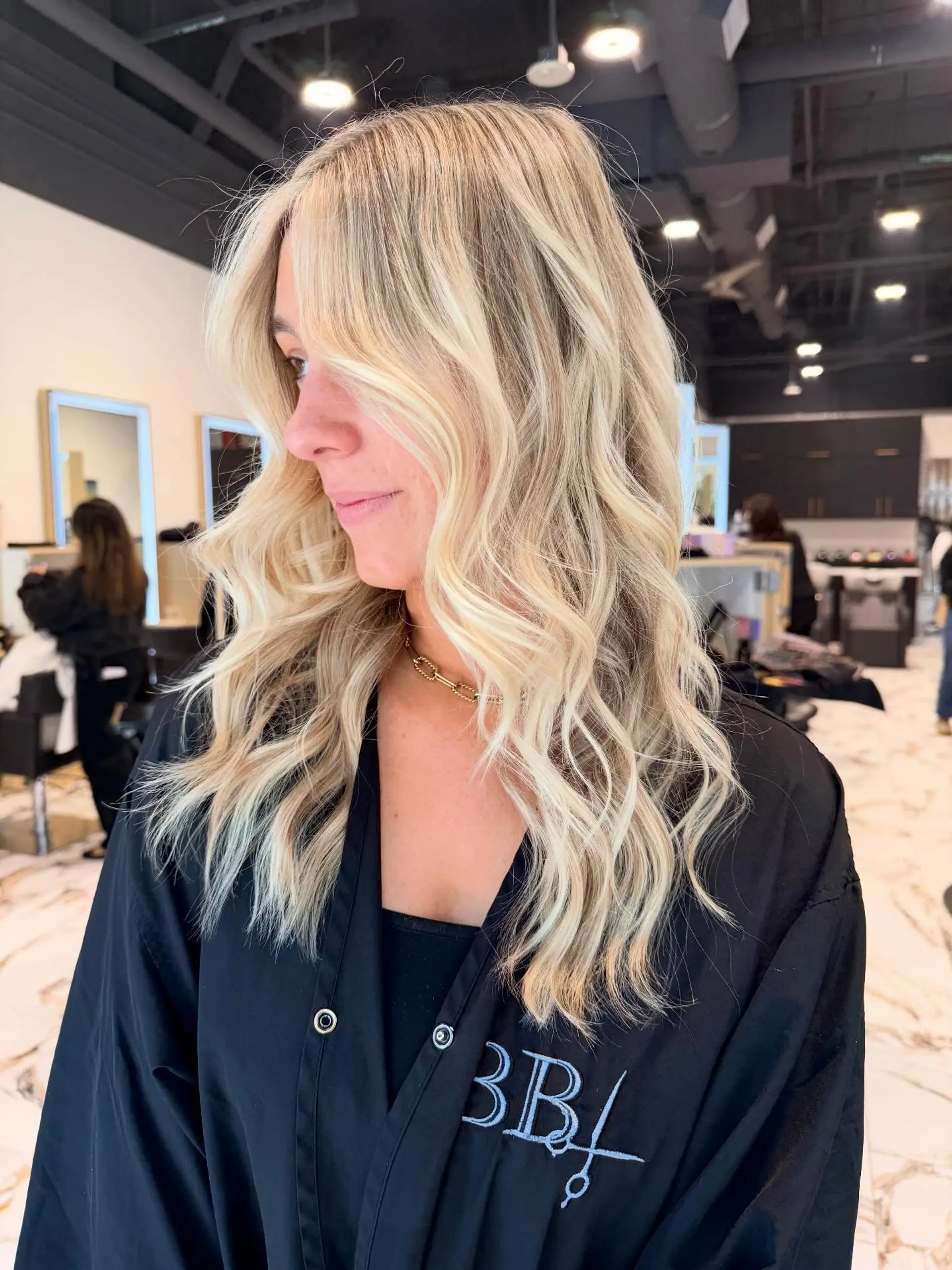 Long sun-kissed blonde hair styled with soft, dimensional waves and face-framing layers. 1