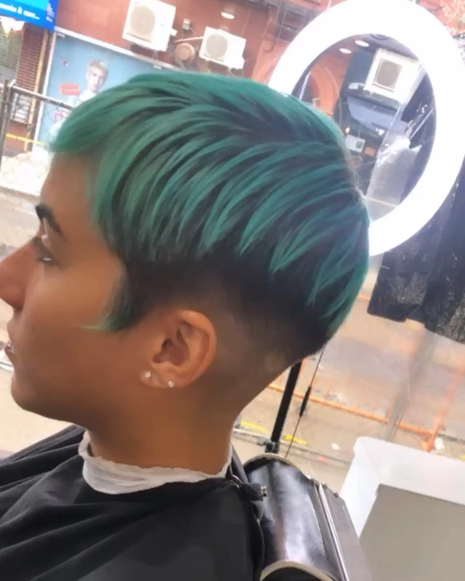 A textured short crop featuring vibrant teal-green tones on top contrasted with a clean skin fade on the sides. 1