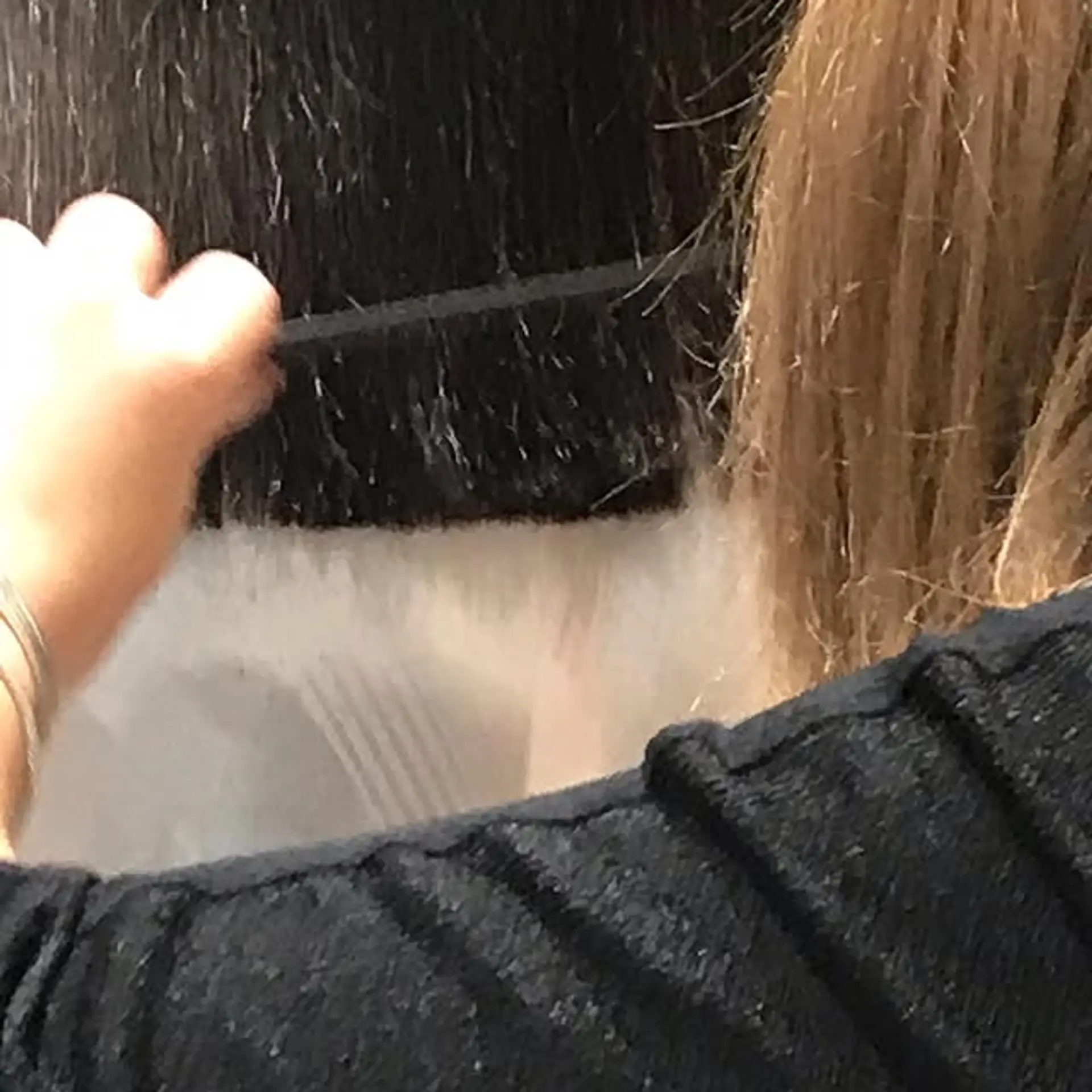 This hairstyle features bleached blonde ends with black roots, creating a stylish two-tone look. 1