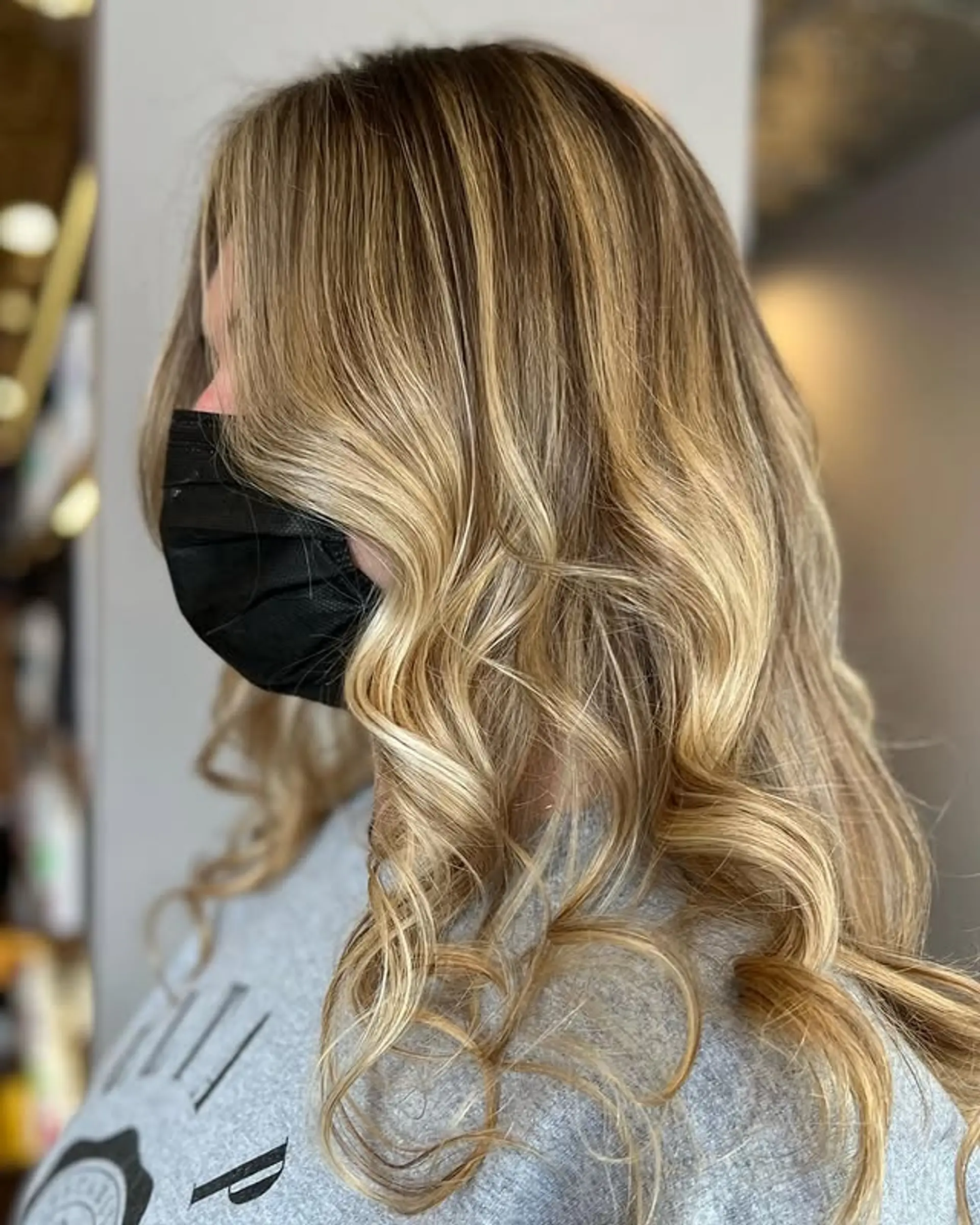 Long, layered waves with a dimensional balayage, featuring golden blonde and caramel tones. 1