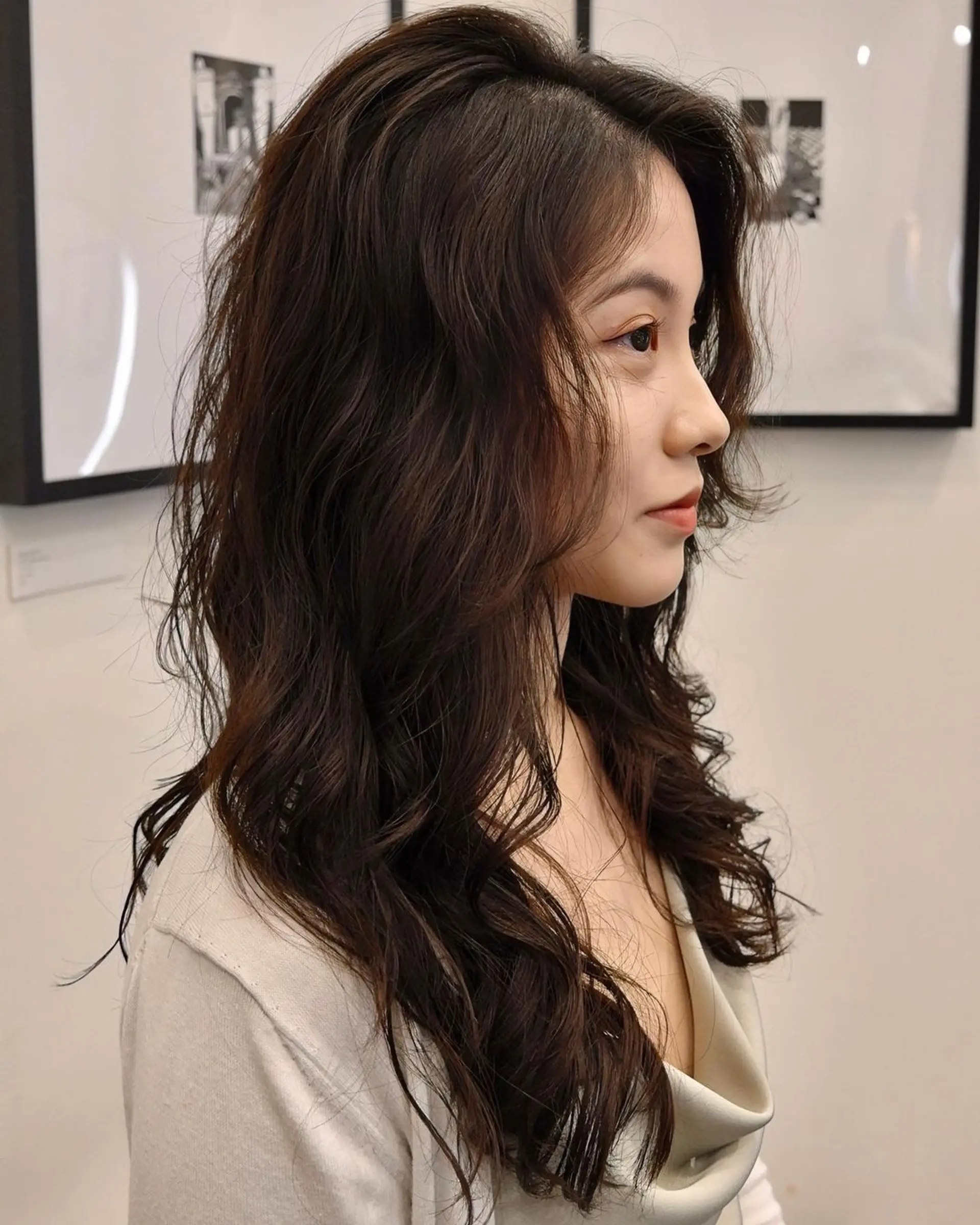 Long, dark brown hair cascades in soft, wavy layers with voluminous locks and side-swept bangs. 👩🏻‍🦱Hair by @hiro.nonstop 👩🏻‍🦱 3