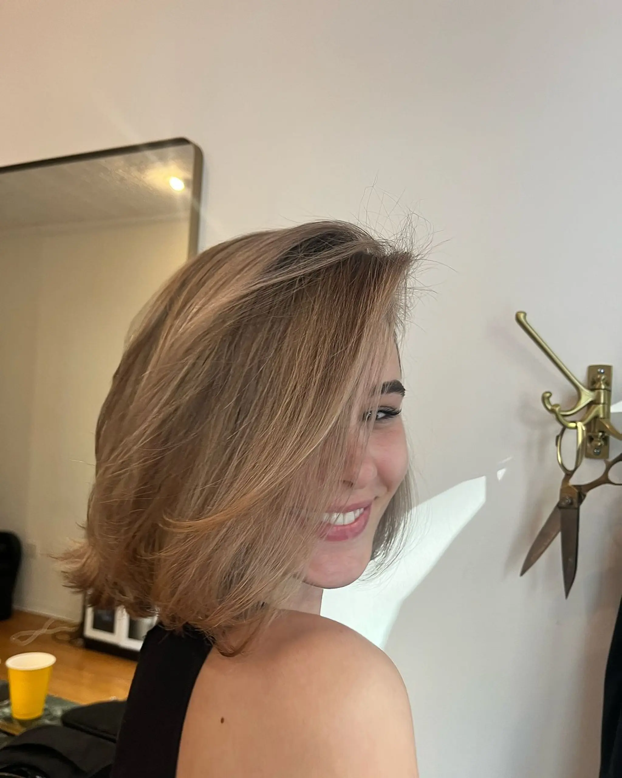 A medium-length, wavy blonde bob with a side part that exudes a soft, chic, and natural elegance. 2