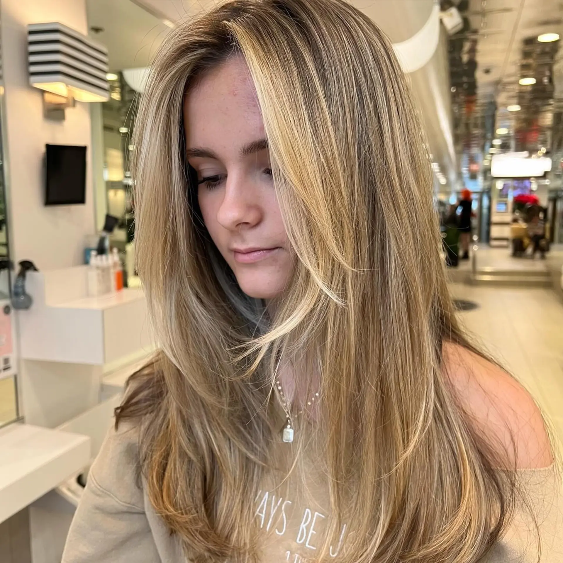 Long dimensional blonde hair cut with cascading face-framing layers and styled with a smooth, voluminous blowout. 1
