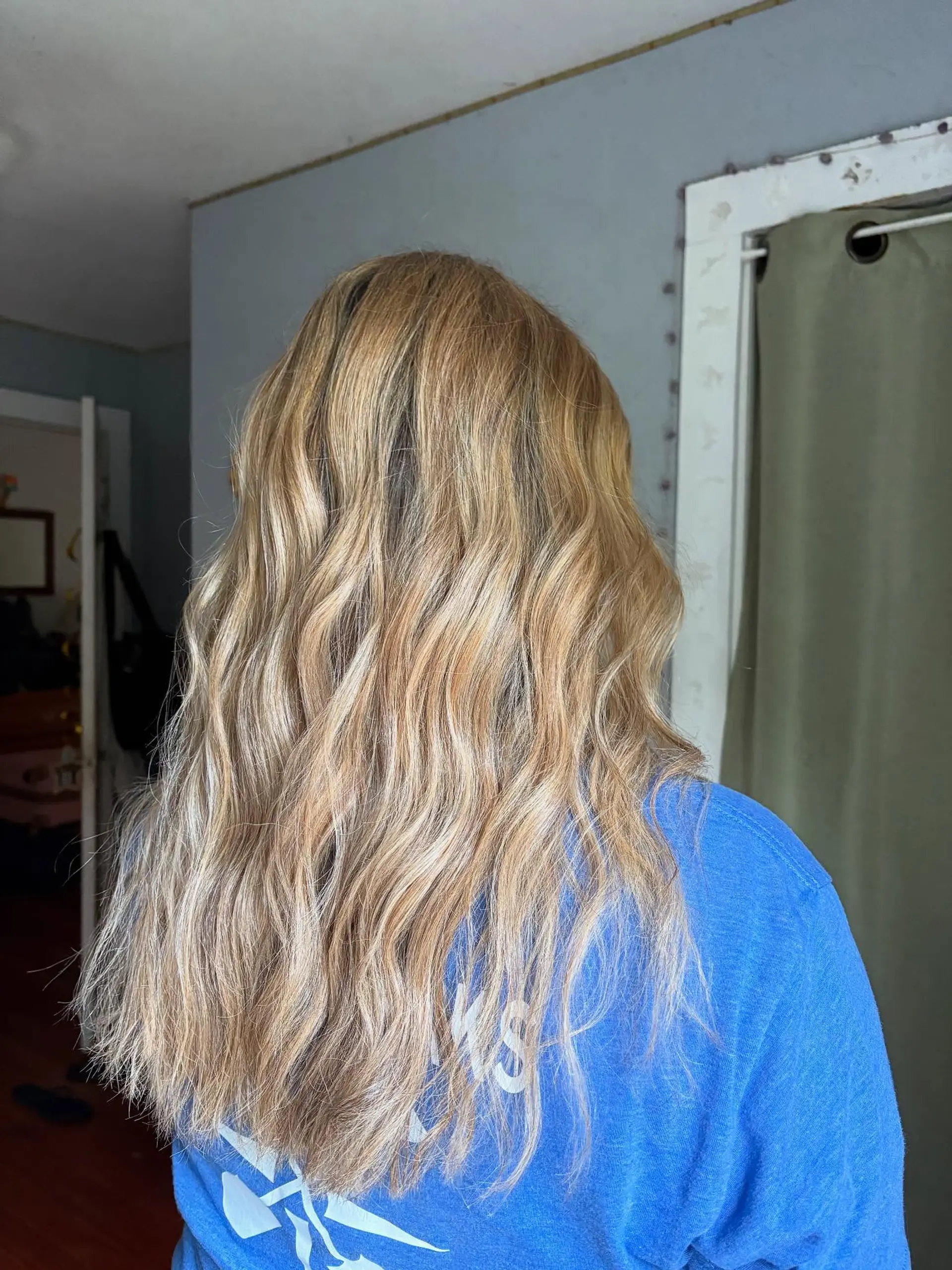 Long golden blonde hair styled into effortless, beachy waves. 1