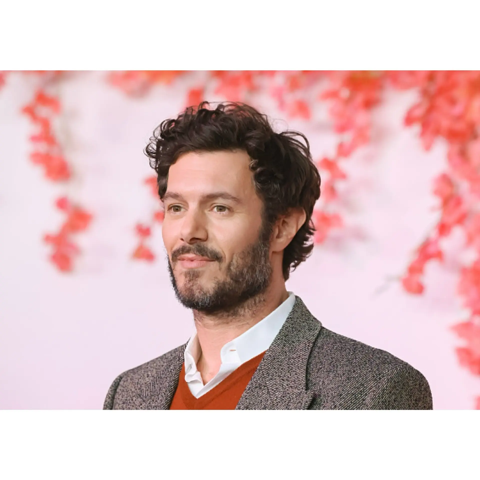 A short men's cut showcasing natural curls and waves with light volume on top and softly trimmed sides. 1