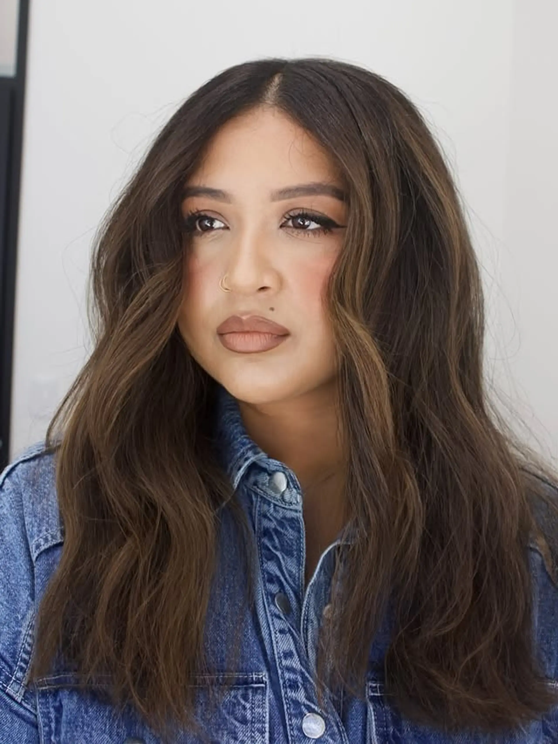 Long wavy hairstyle with face-framing layers and subtle bronze highlights. 1