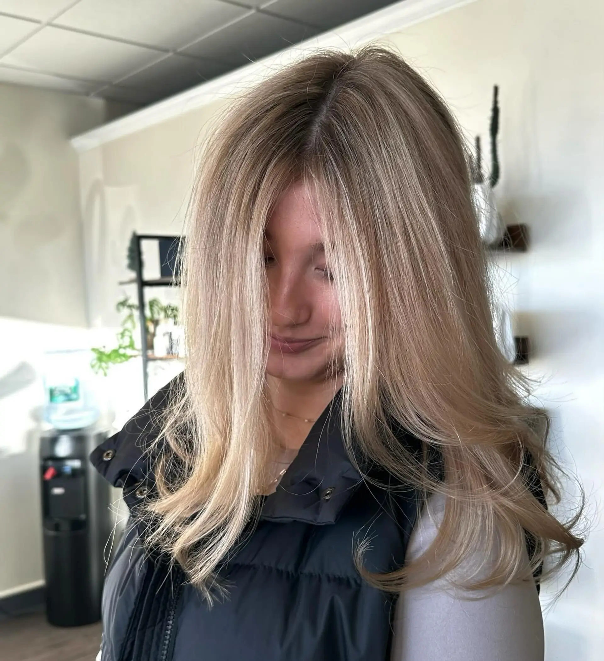 Smooth, voluminous blowout showcasing creamy sandy beige blonde highlights with soft curved ends. 1