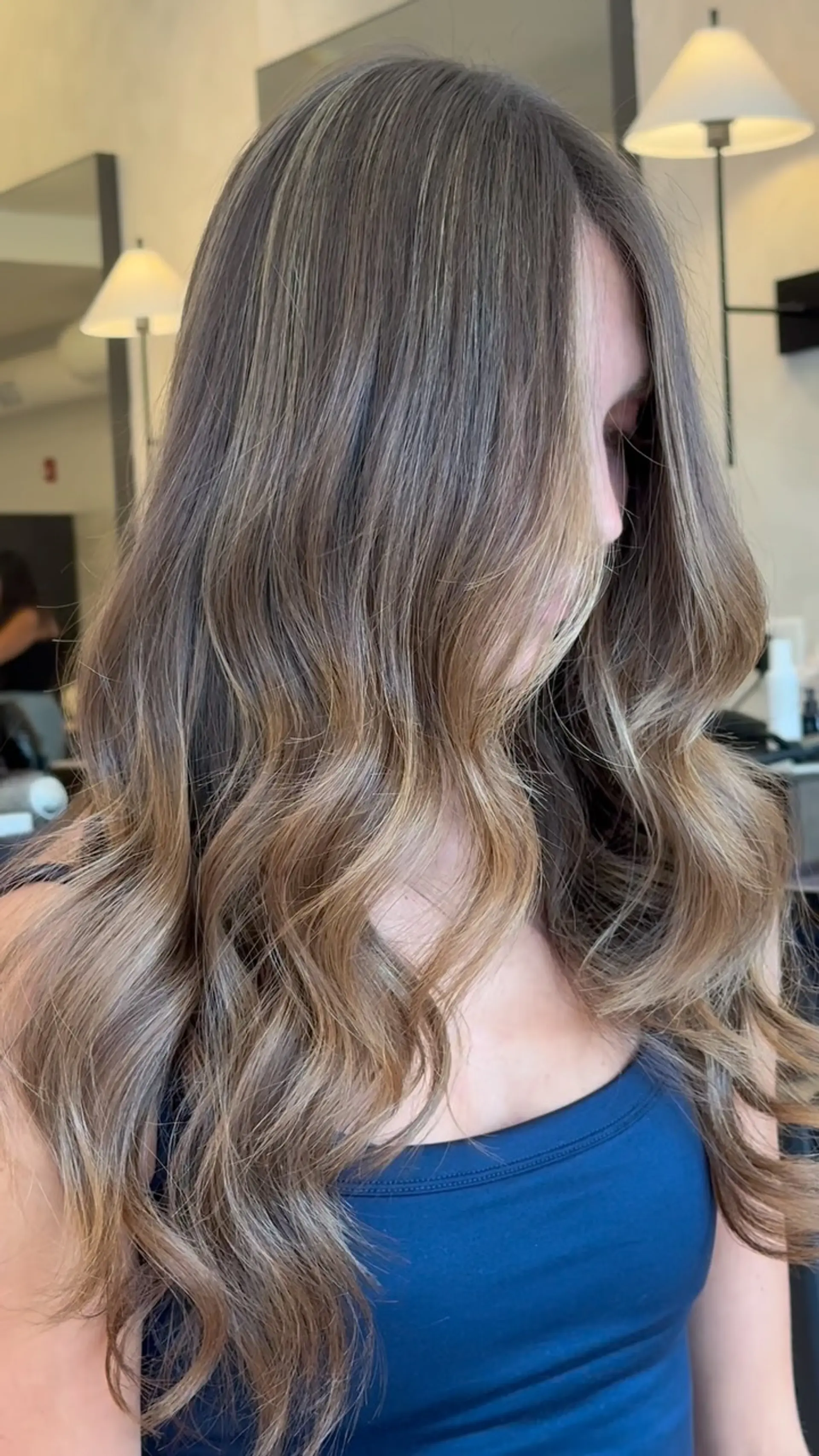 Long dimensional brunette hair styled into soft, flowing loose waves with seamless sun-kissed highlights. 1
