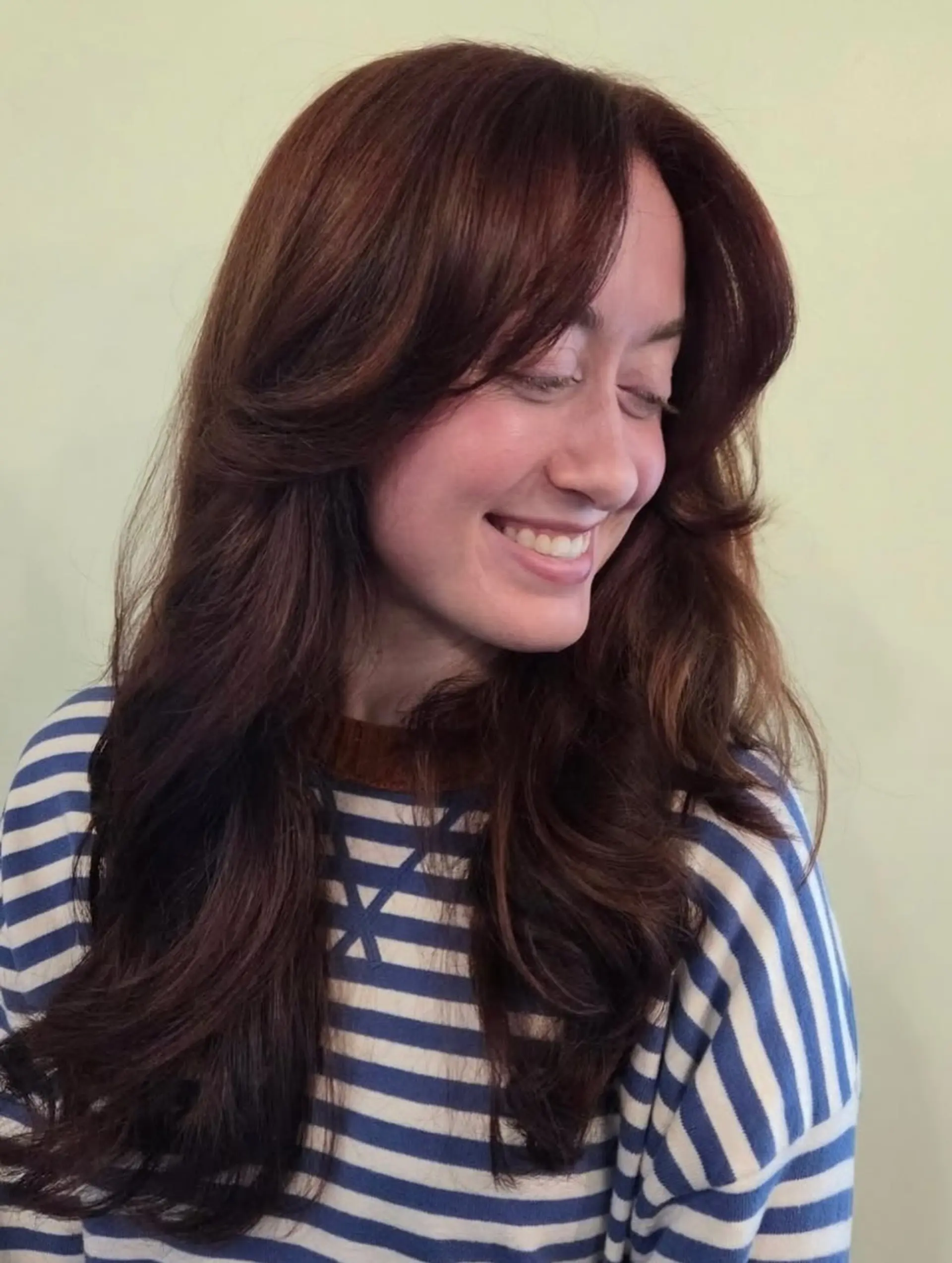 Long warm brown hair styled with soft, voluminous waves and cascading face-framing curtain layers. 1