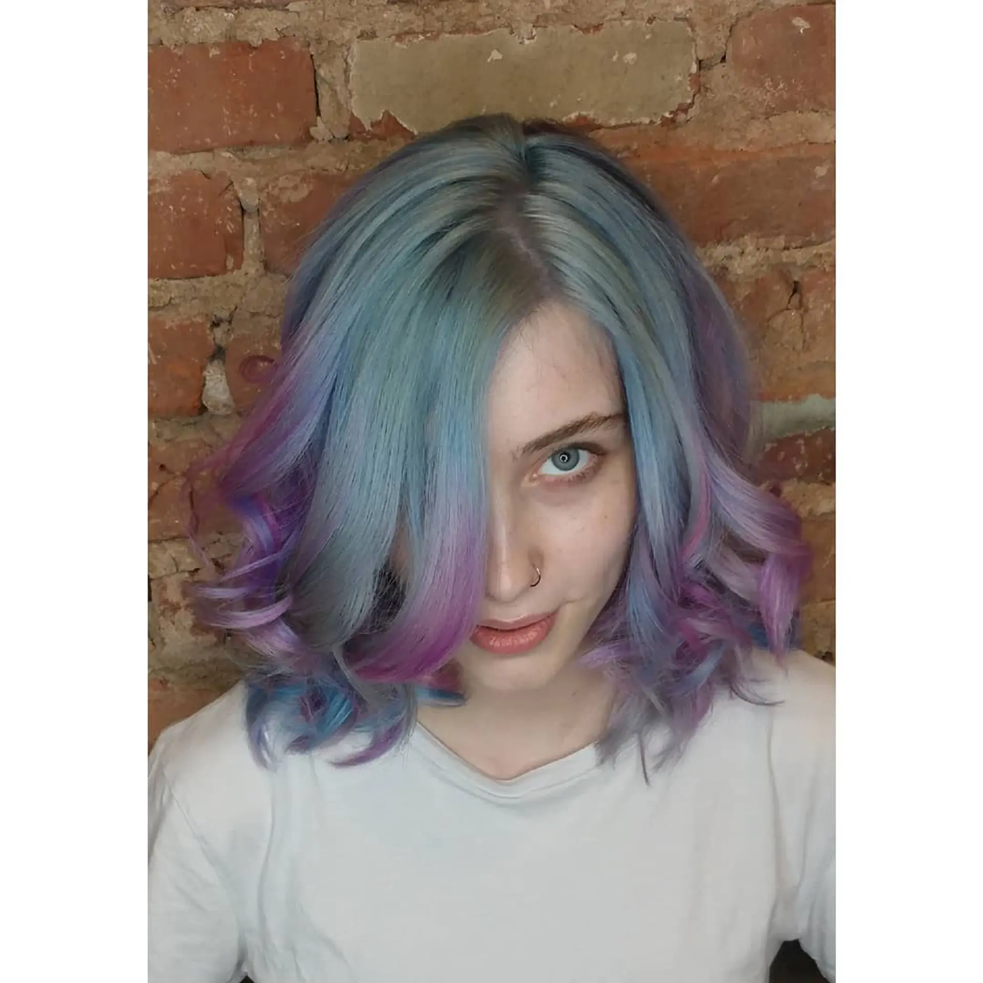 Medium-length wavy lob featuring a blend of pastel blue, lavender, and soft pink shades styled in voluminous, face-framing curls. 1