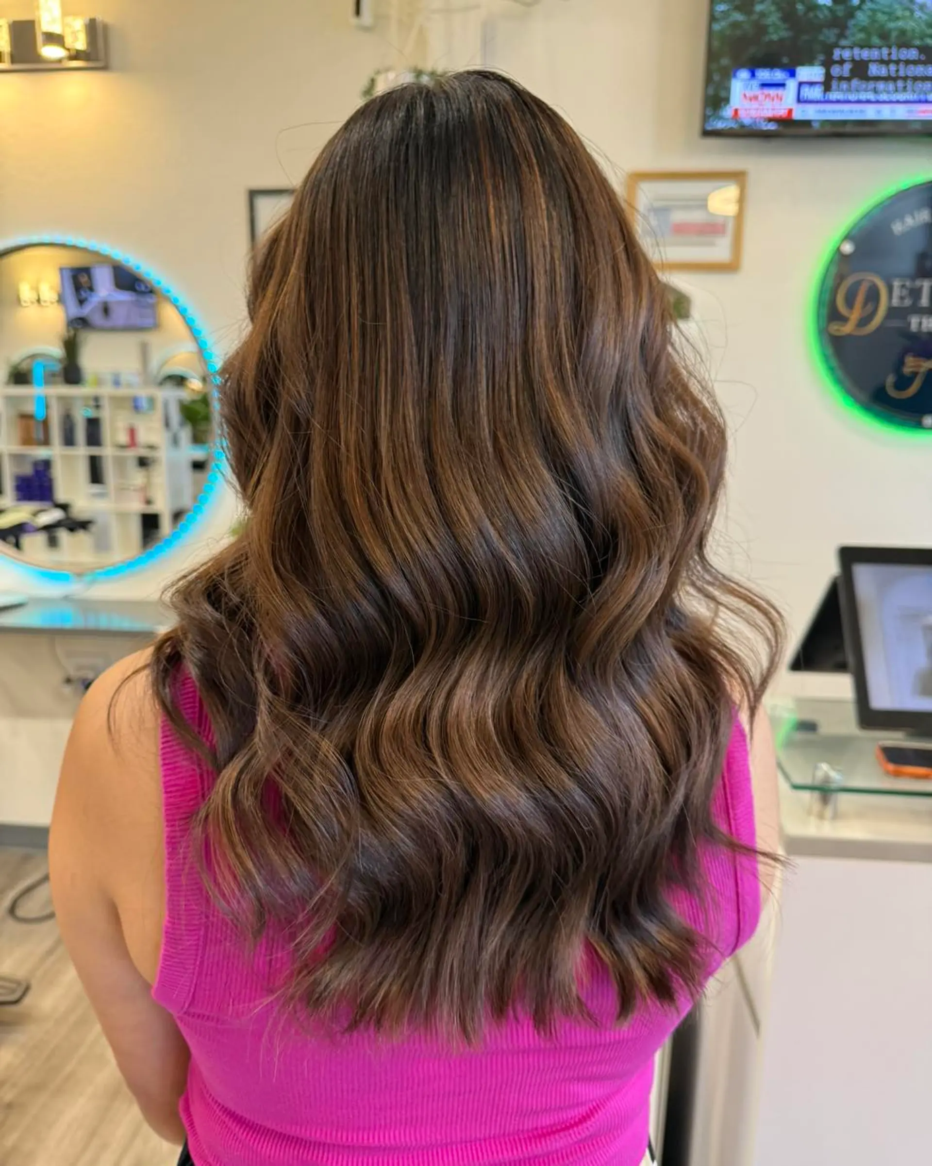 Rich chocolate brown base with subtle, dimensional warm caramel balayage highlights styled in soft waves. 1