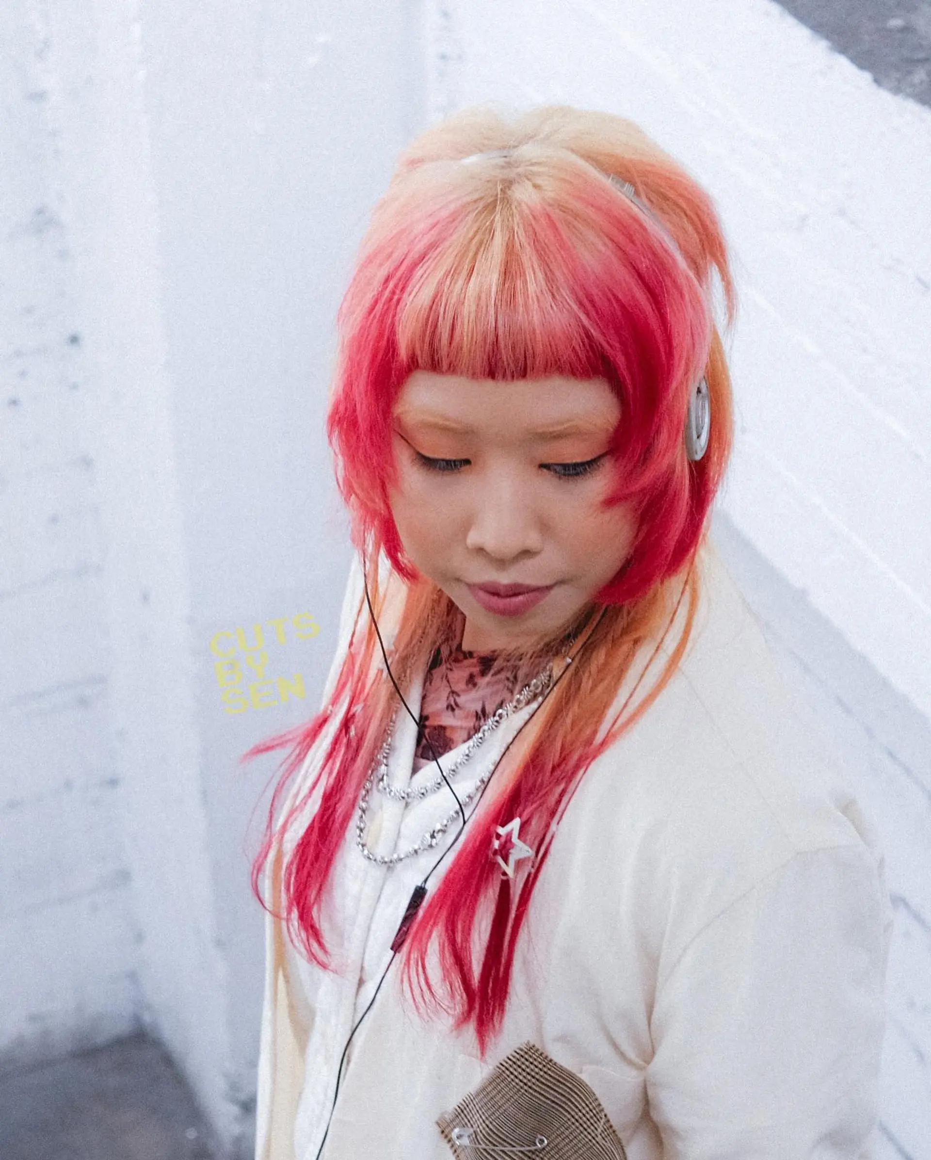 A creative textured hime cut featuring blunt micro bangs, cheek-length side pieces, and bold pink color blocking on a peach-blonde base. 1
