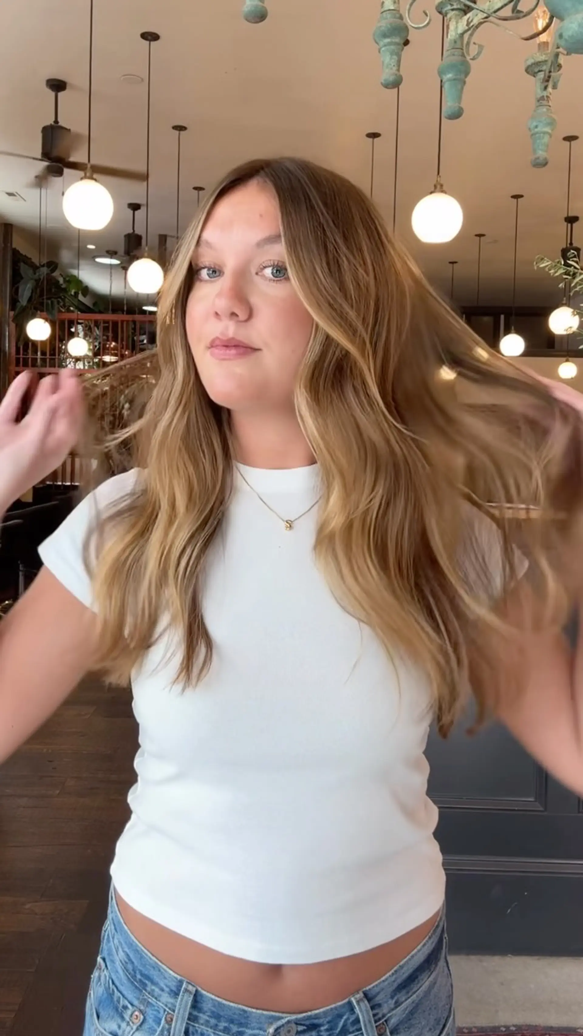 Long dimensional bronde hair styled into soft, effortless waves with face-framing layers. 1