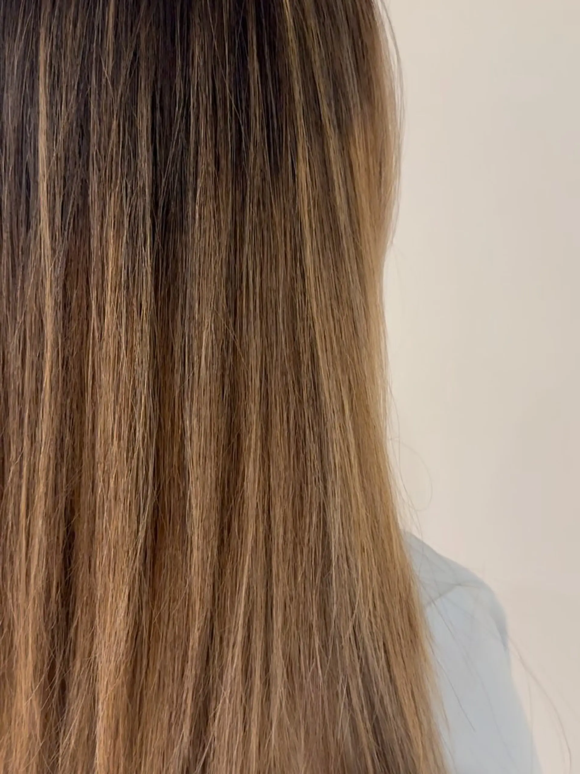 Straight, long bronde hair featuring soft, blended warm highlights. 1