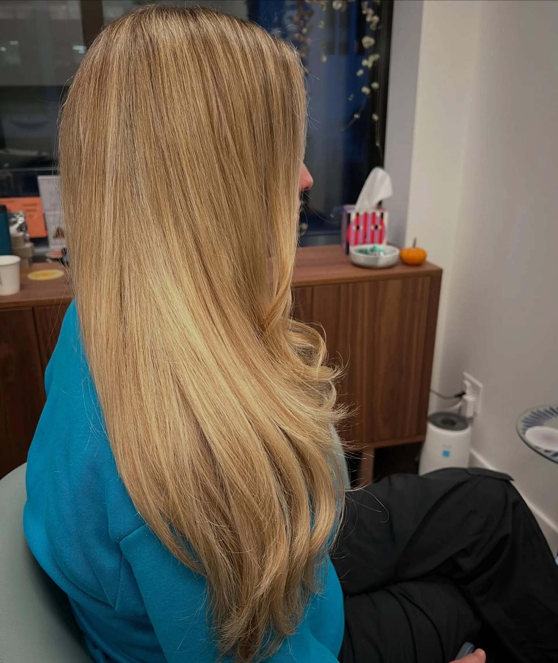 Long honey blonde hair styled smooth and sleek with face-framing layers and soft, curled ends. 1